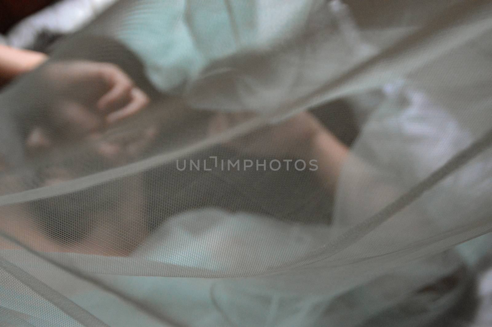 Conceptual photo of a man half hidden by a thin veil showing the concept of gender identity, intimacy and sensuality