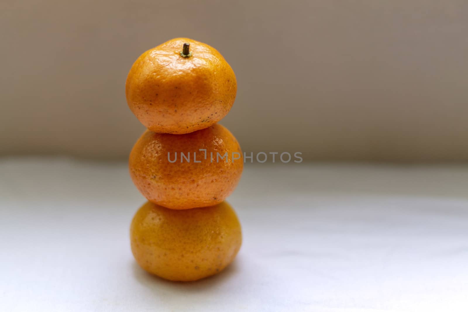 Three tangerines stacked on top of each other