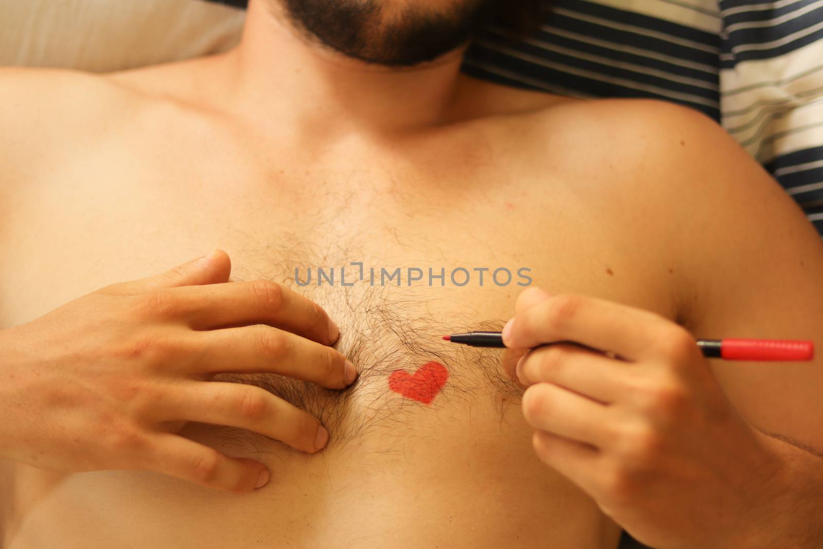 Close up of a heart drawing on a naked male chest showing the concept of vulnerability, falling inlove and gender