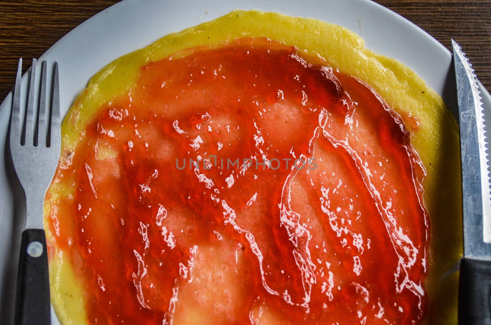 Close up of pancake smeared with strawberry jam