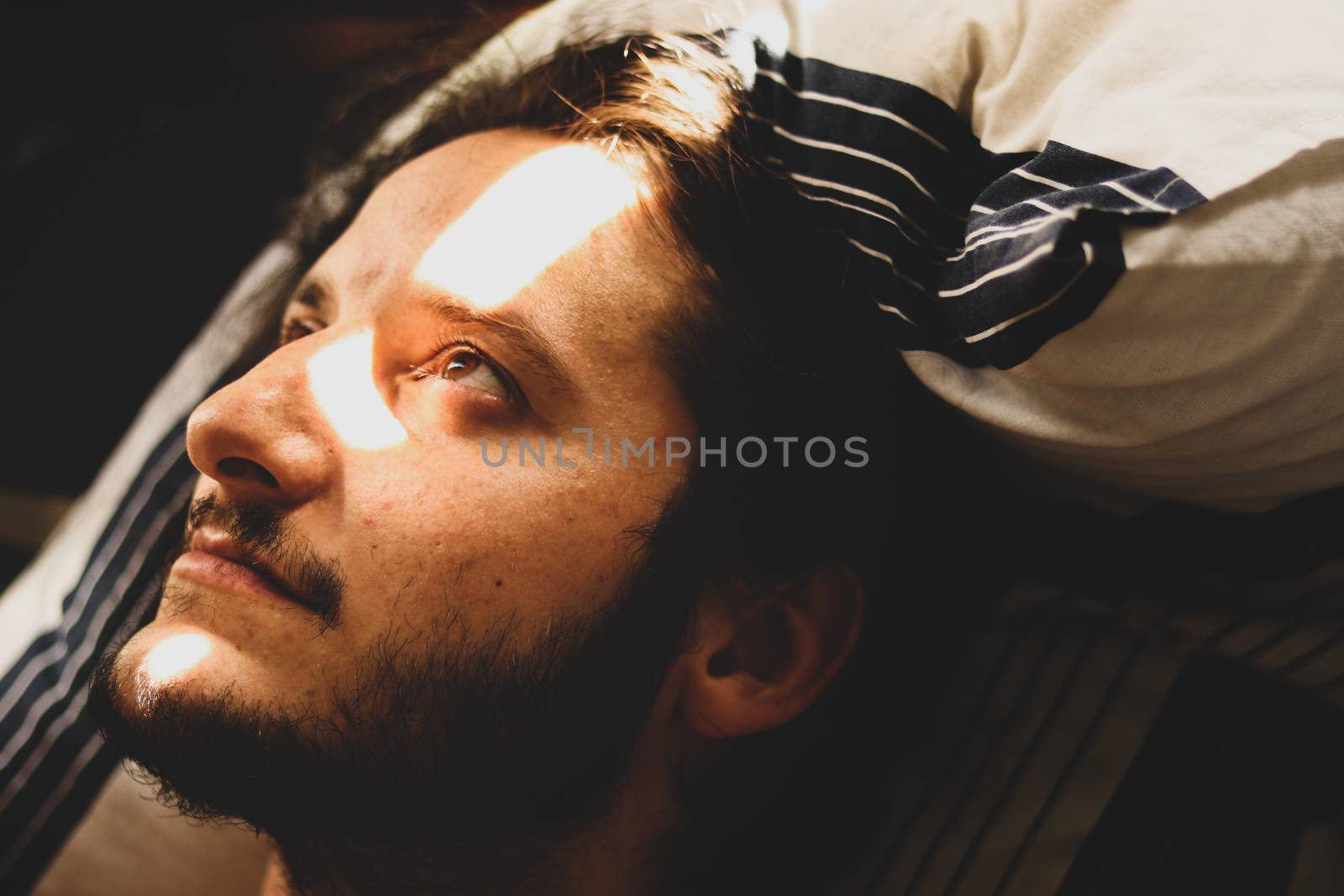 Portrait of a man looking up to a light from a bedroom window