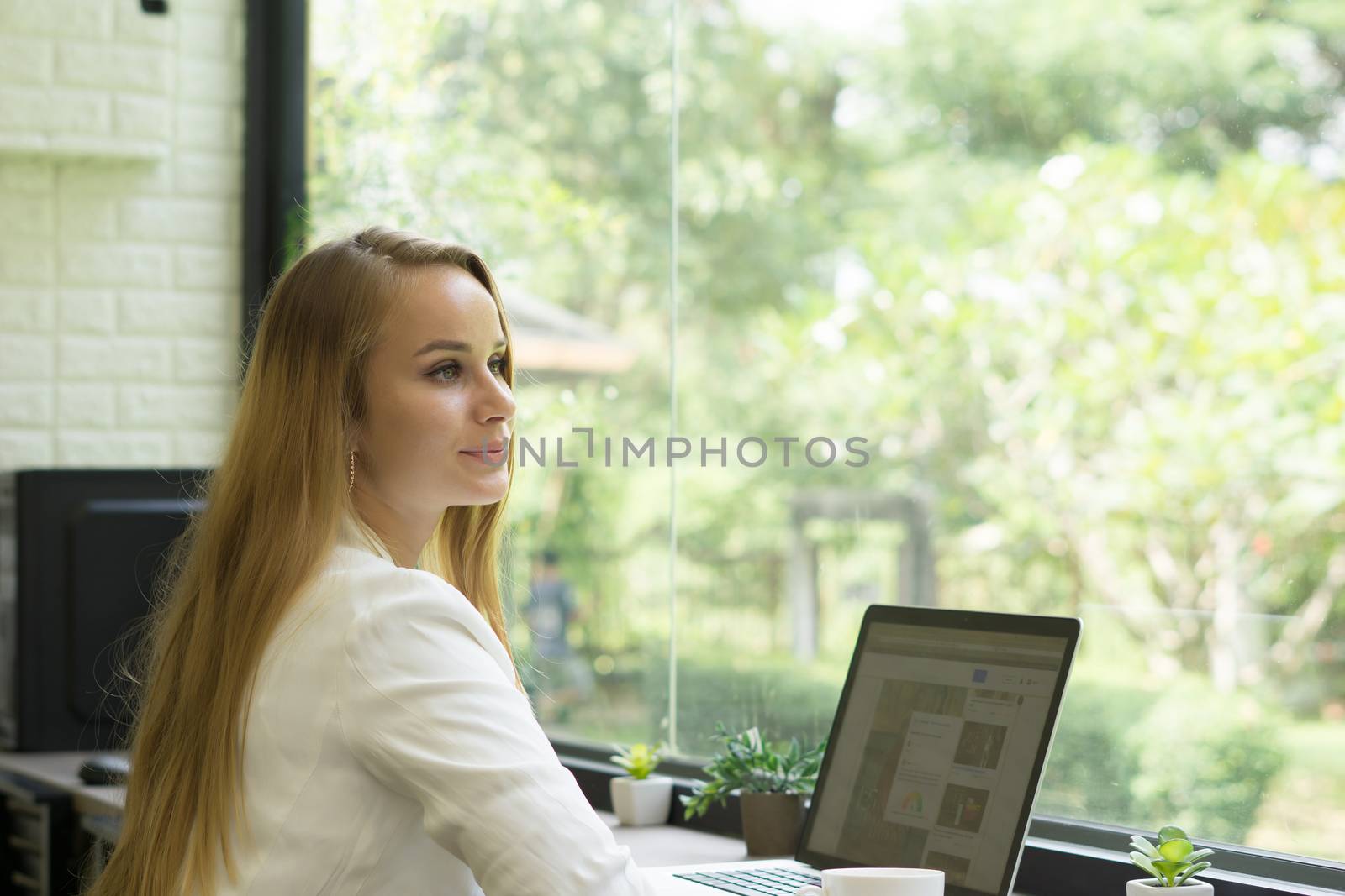 Young business woman working on her laptop at office.