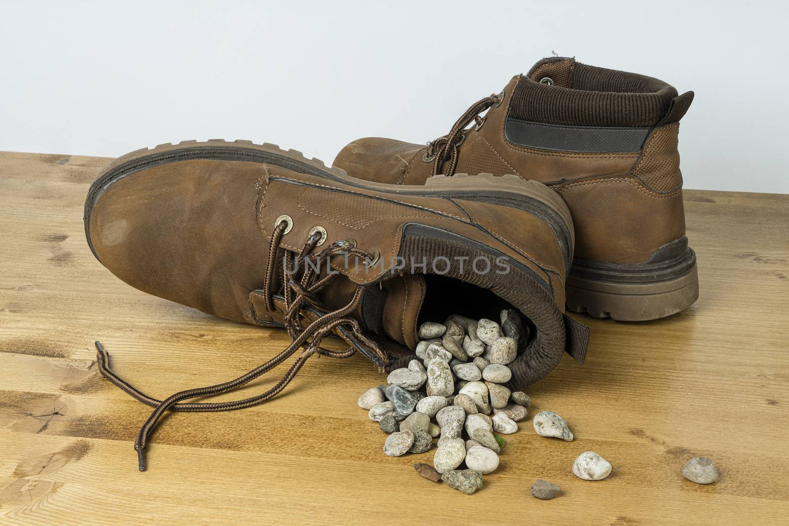 a shoe full of gravel overturned on a wooden surface