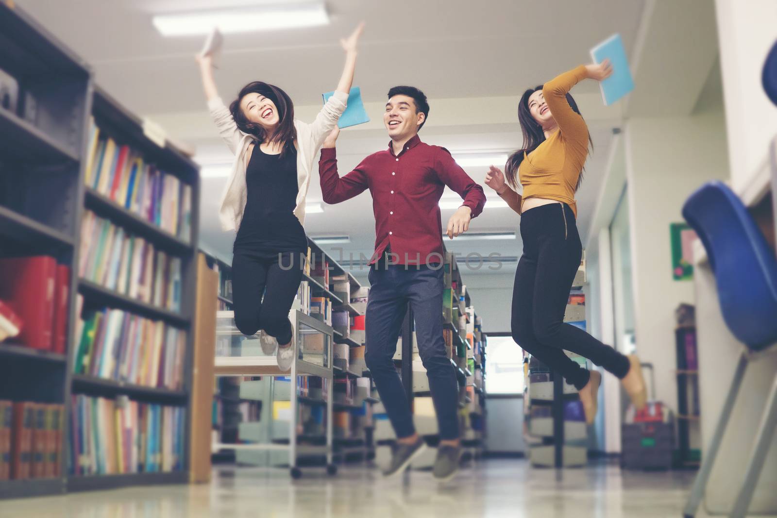 Group of student jumping in the library seem so happy.