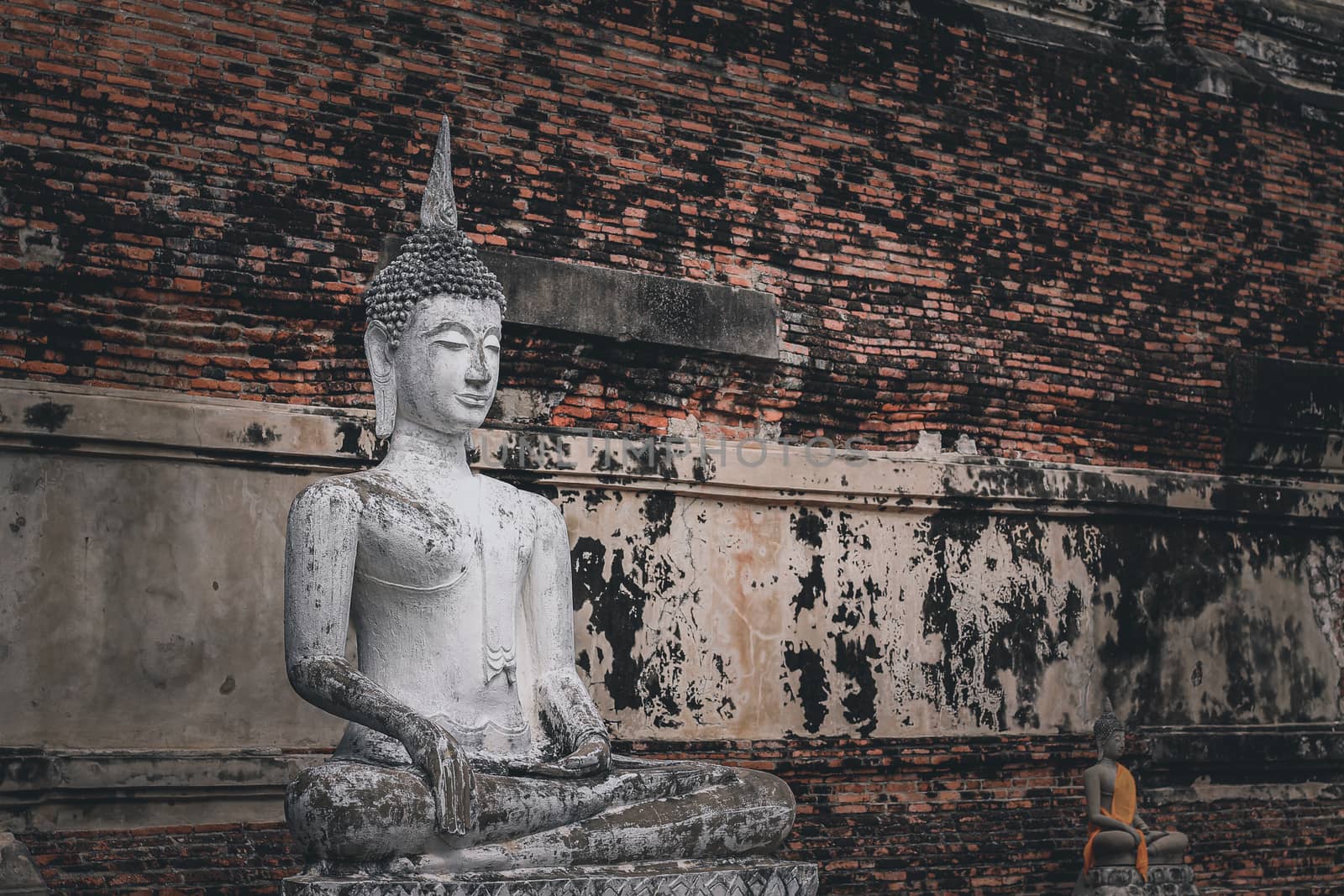 Statue of Buddha at the Ayutthaya Historical Park showing the religion, local thai culture and history of Thailand