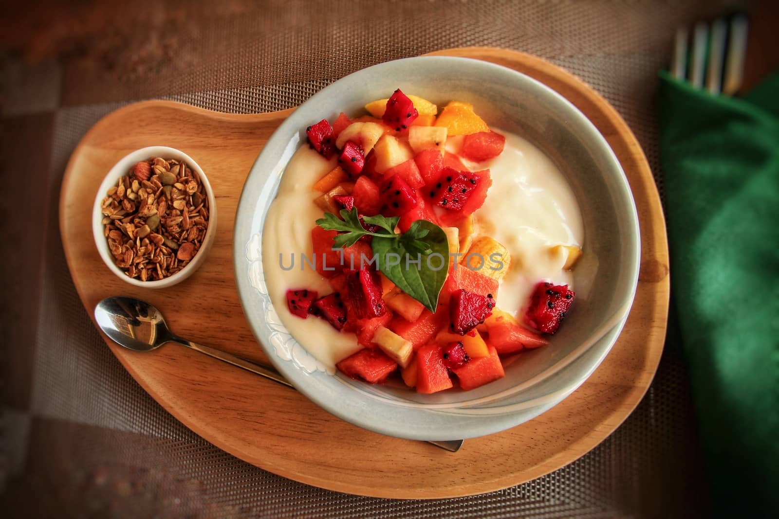 Full vegan breakfast of tropical fruit smoothie bowl with muesli as a way to stay healthy and cope during home quarantine due to the covid-19 pandemic