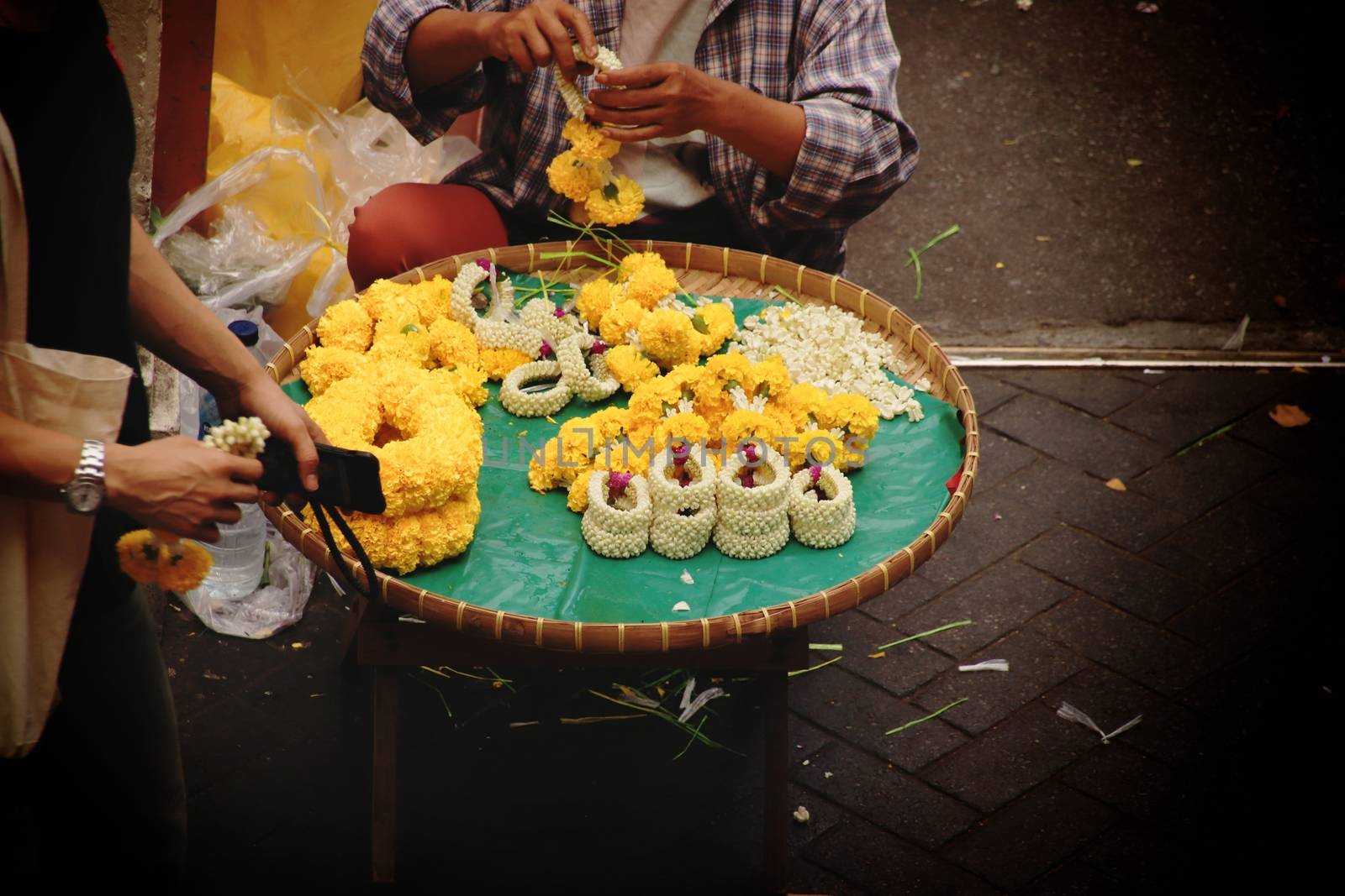 Thai street vendor selling Phuang malai or malai, which is a flower garland used for buddhist offerings and charms for good luck in the Thai culture and religion