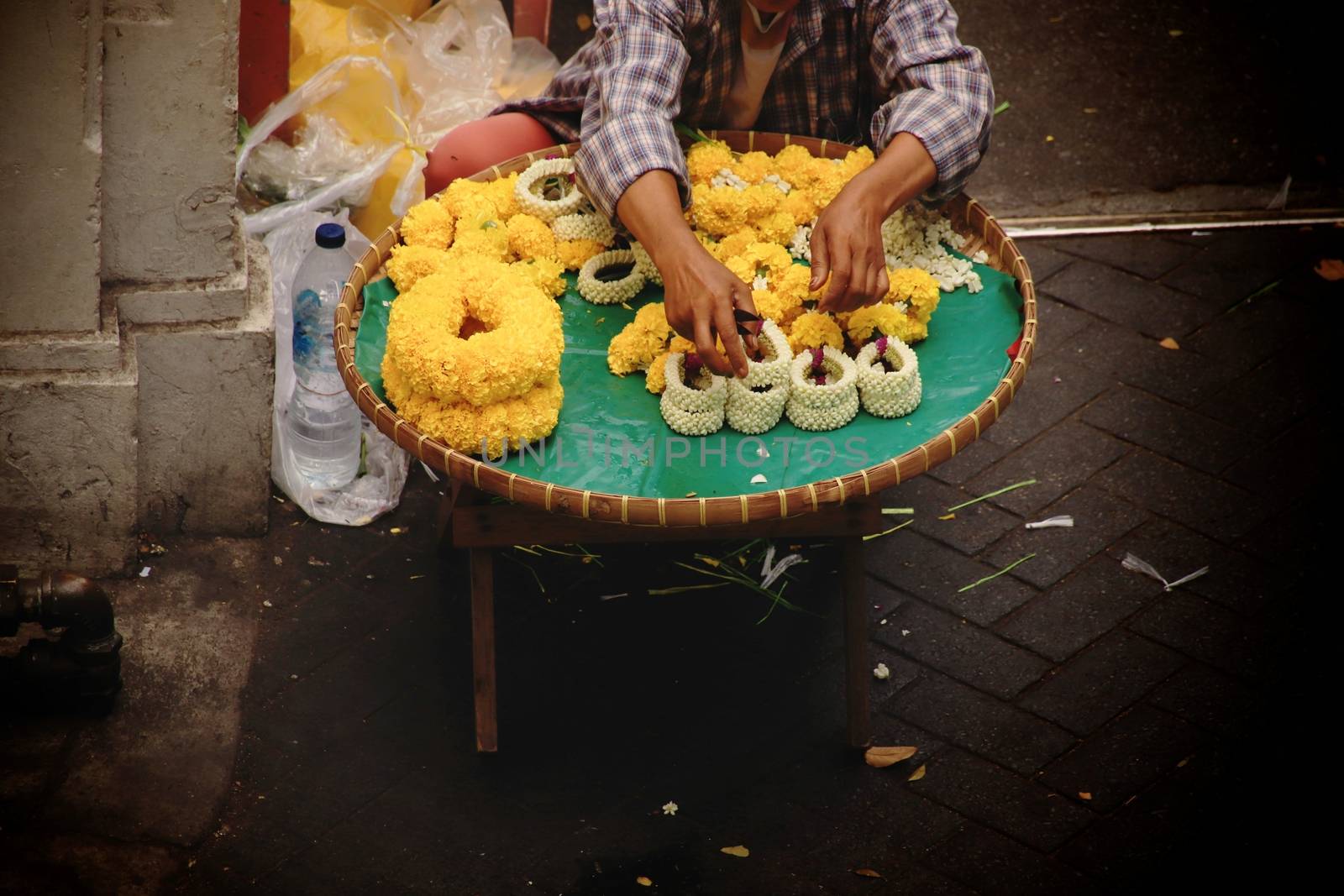 Thai street vendor selling Phuang malai or malai, which is a flower garland used for buddhist offerings and charms for good luck in the Thai culture and religion