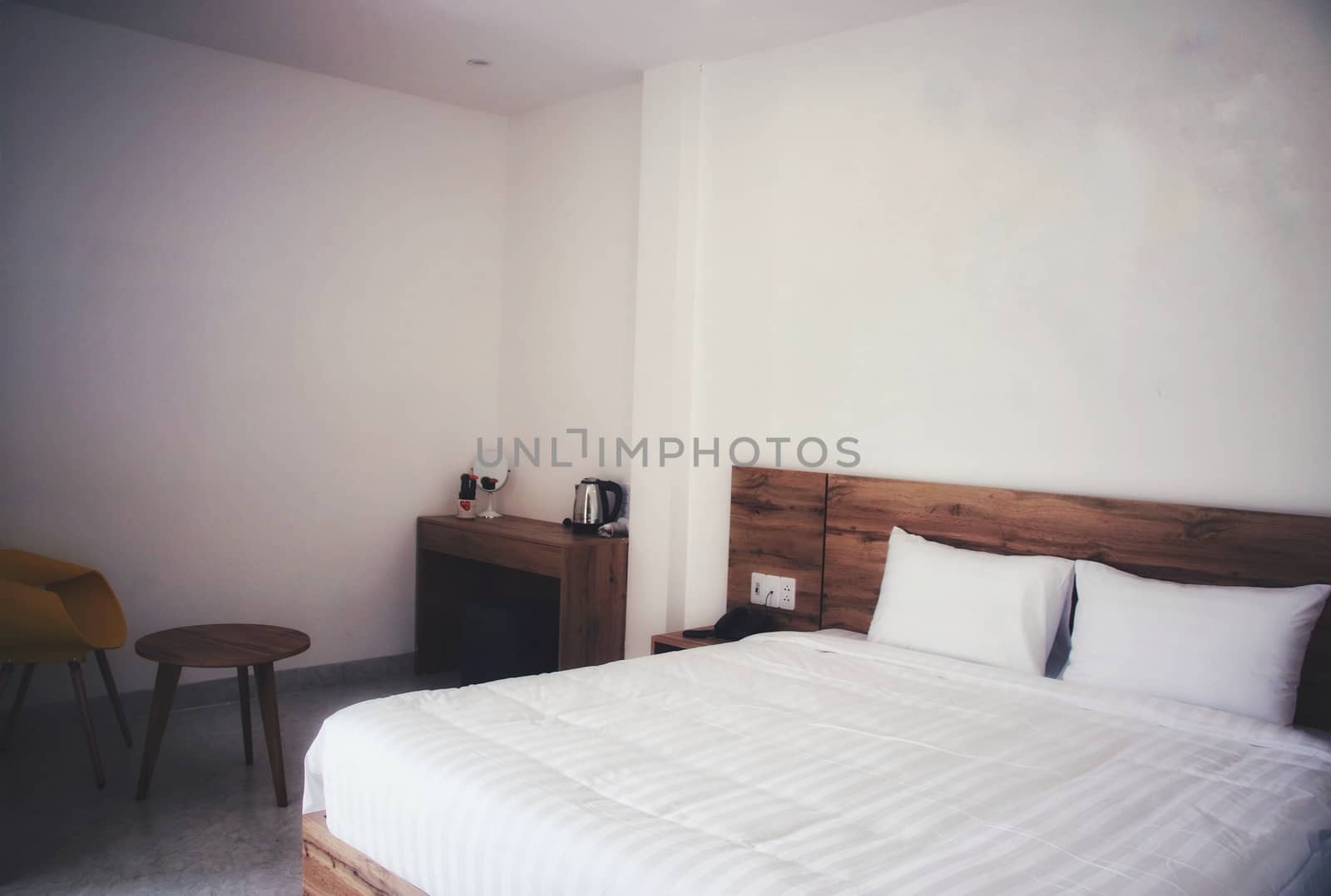 Clean and simple white bedroom with a double bed