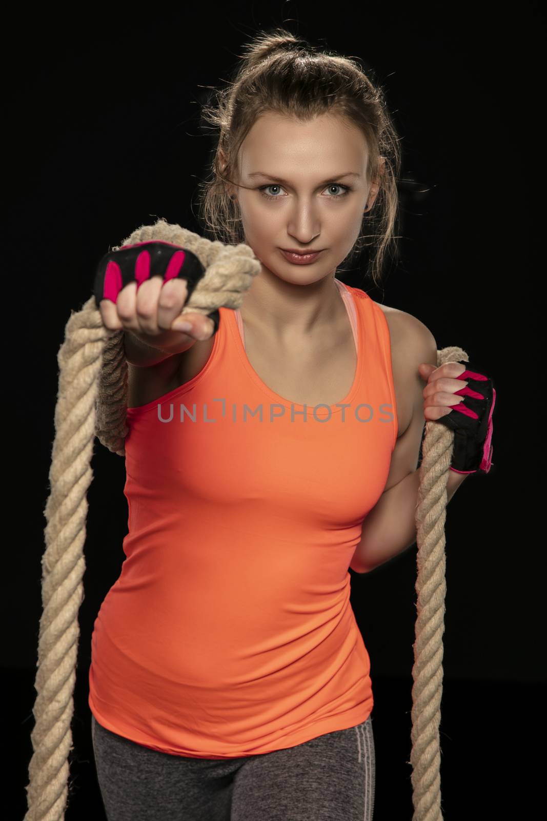 athletic girl exercising with a thick rope