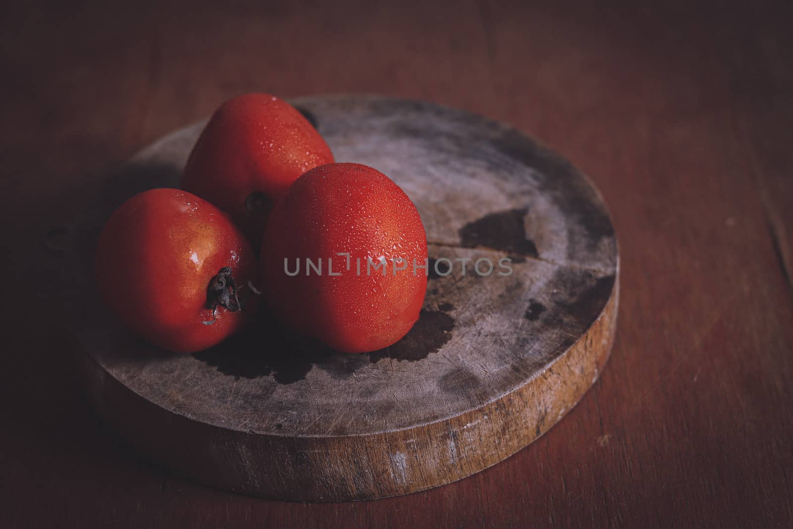 Red tomatoes shot in low light to show concept of gastronomy, clean living and healthy diet
