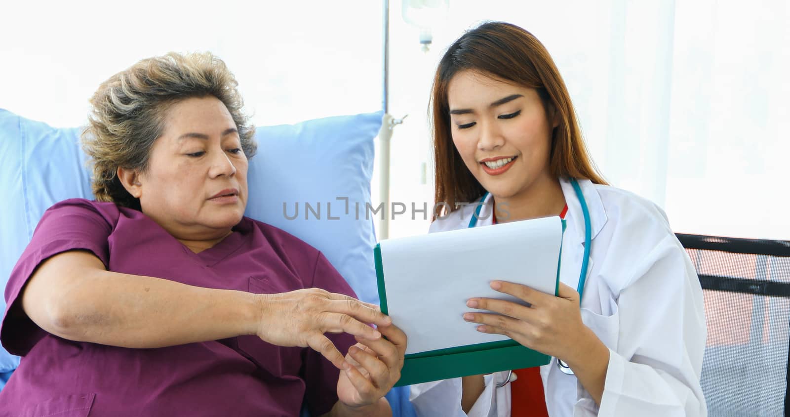 Doctor meeting and explaining medication to old woman patient at Hospitals