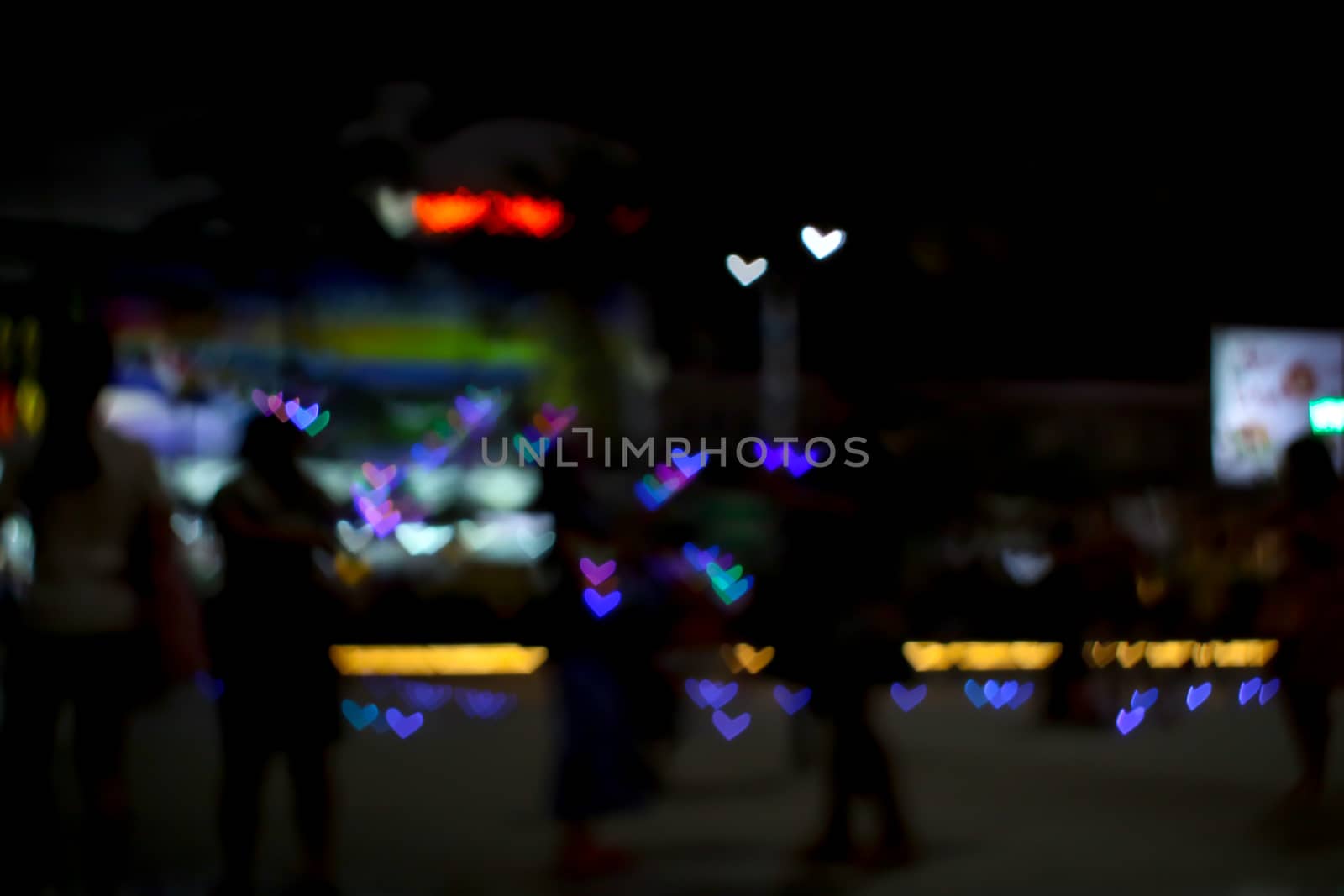 blur people selfie with heart shape love valentine colorful object on night light of shopping mall