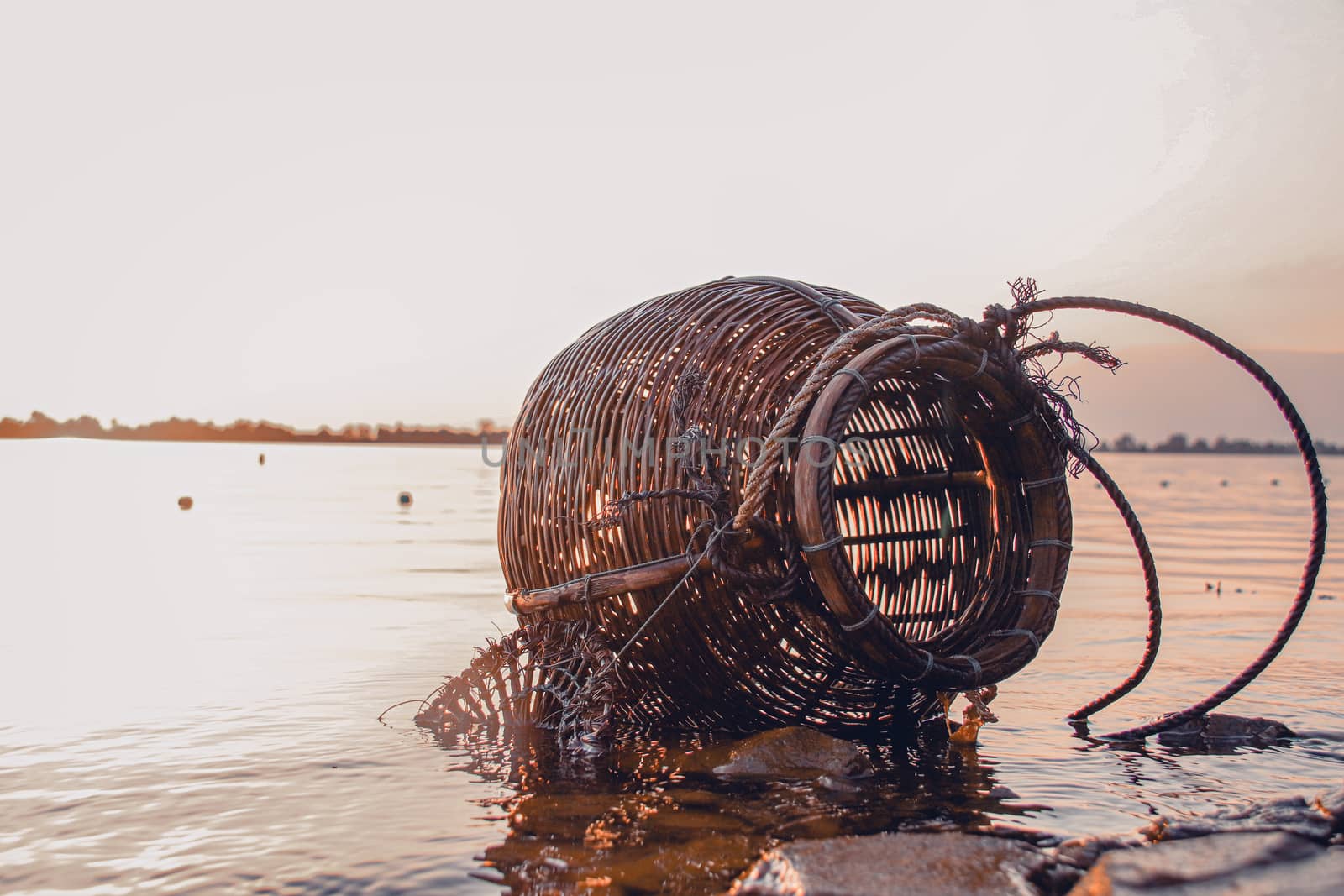 Woven rattan creel or fishing basket that is a traditional fish container in rural fishing village in Cambodia that shows authentic life and local culture