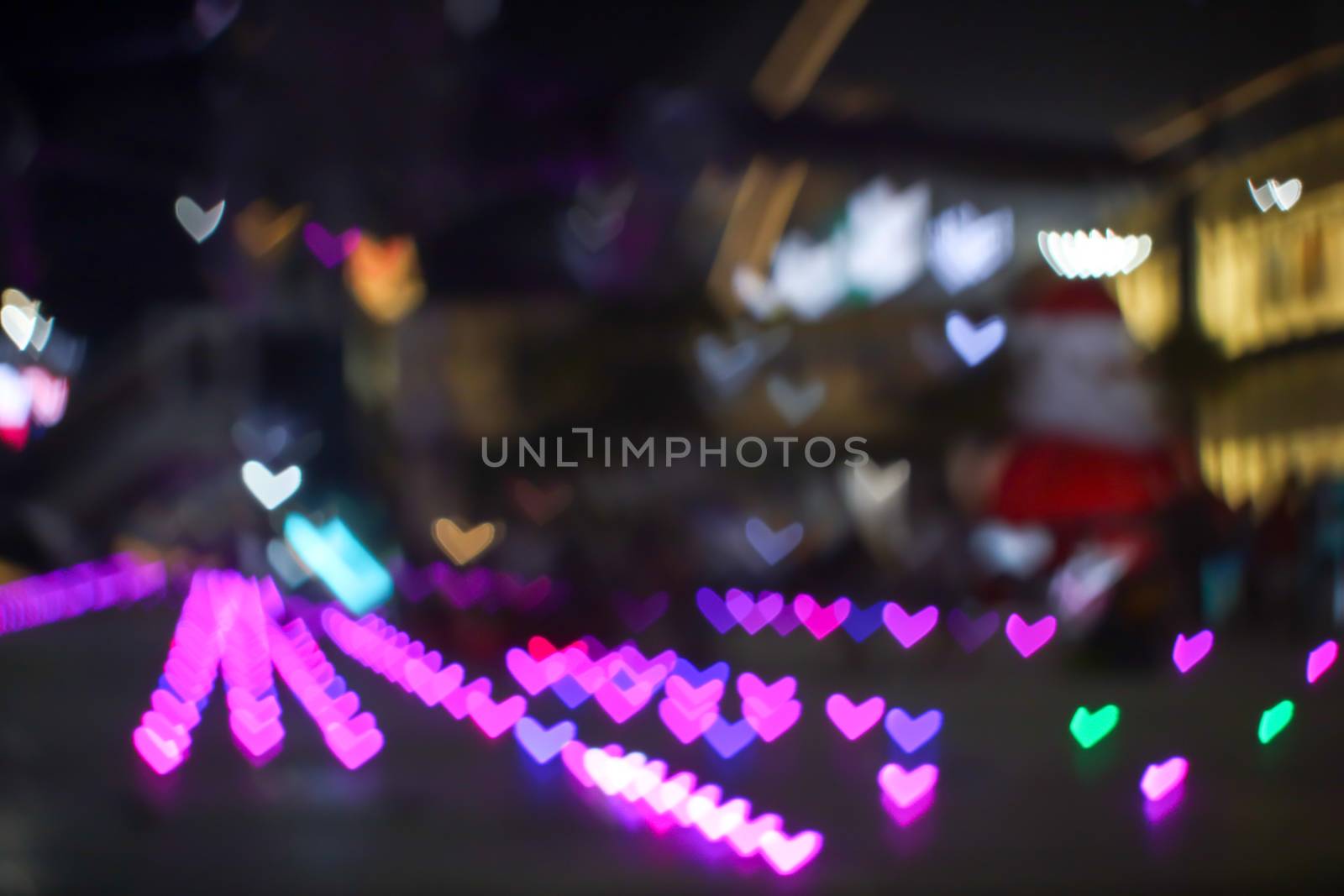pink magenta bokeh and blur heart shape love valentine colorful night light on floor at shopping mall