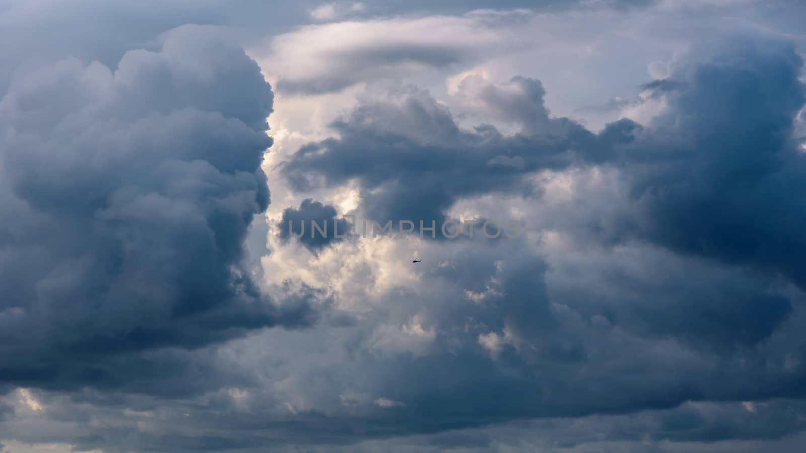 Natural background made of dark stormy cumulus clouds at sunset