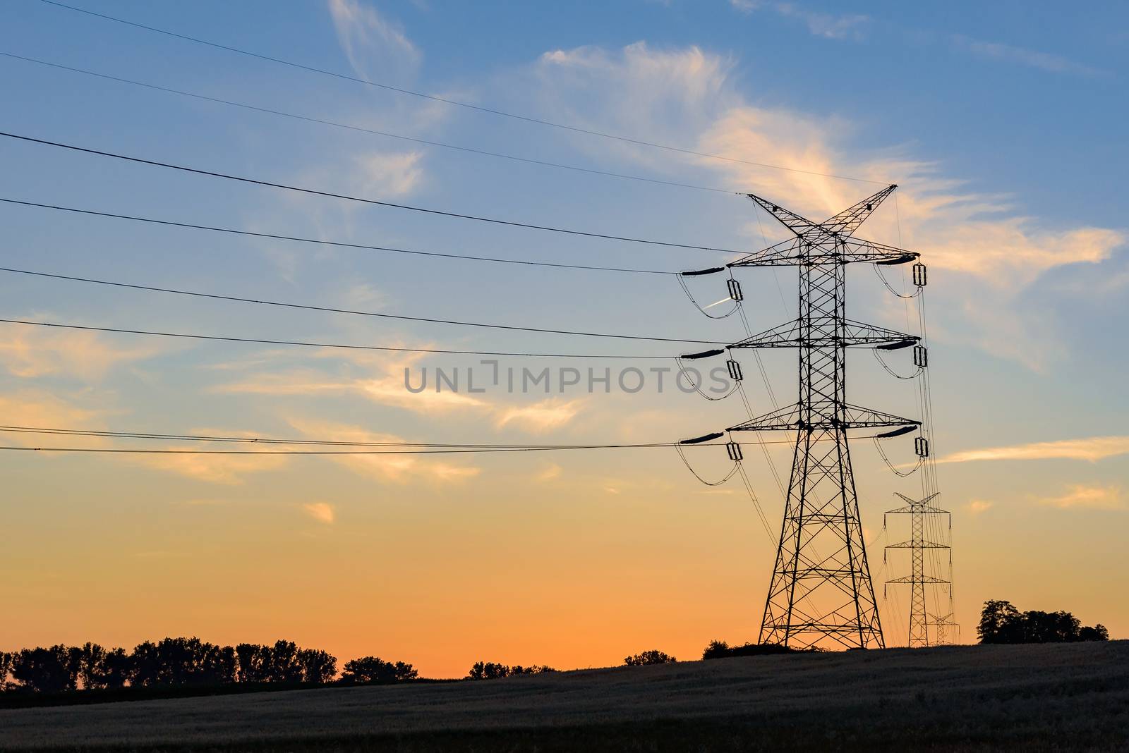 Electricity pylons and lines at sunset by mkos83