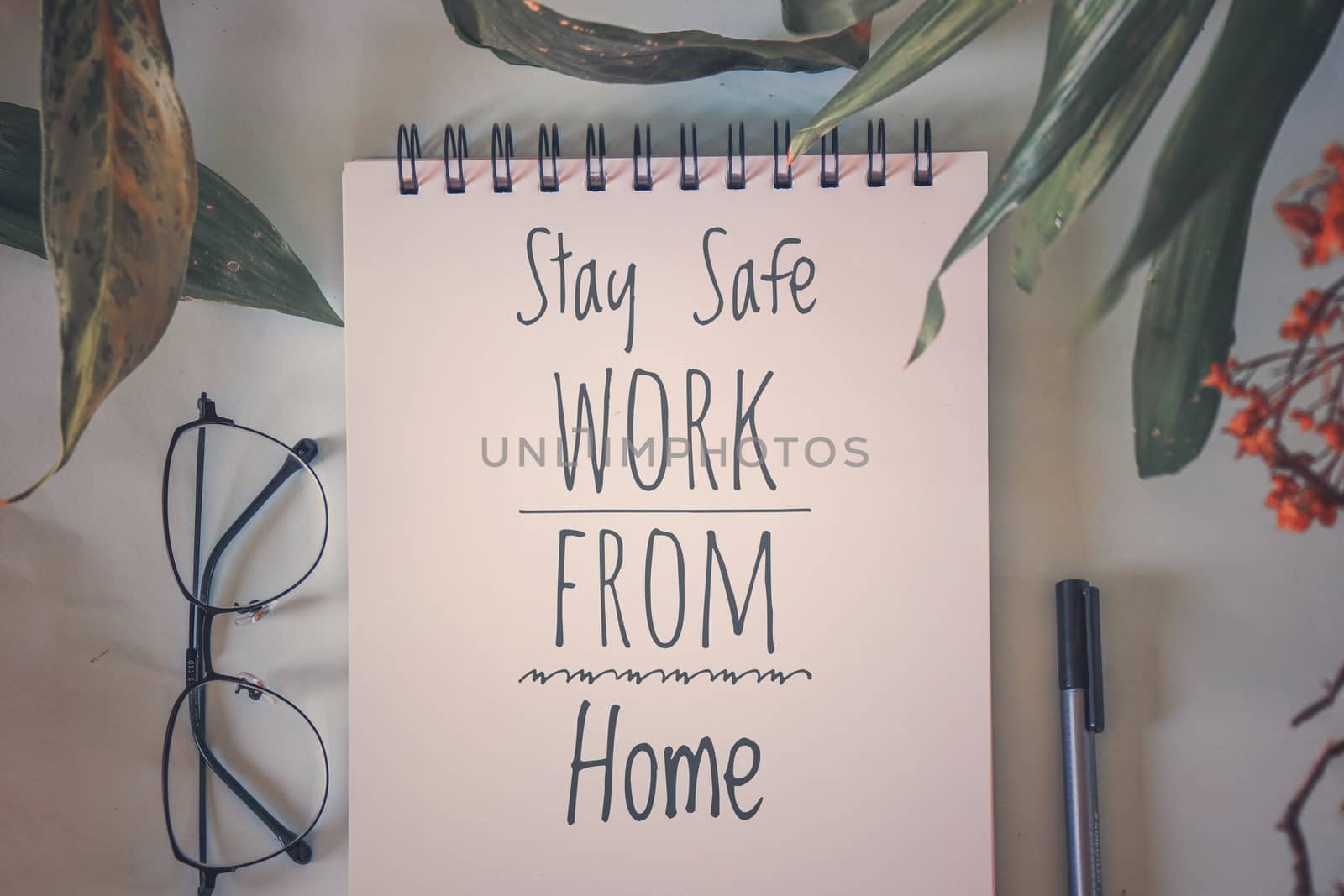 Photo and text overlay promoting work from home as a way to cope with the covid-19 pandemic, staying safe and living the new normal lifestyle