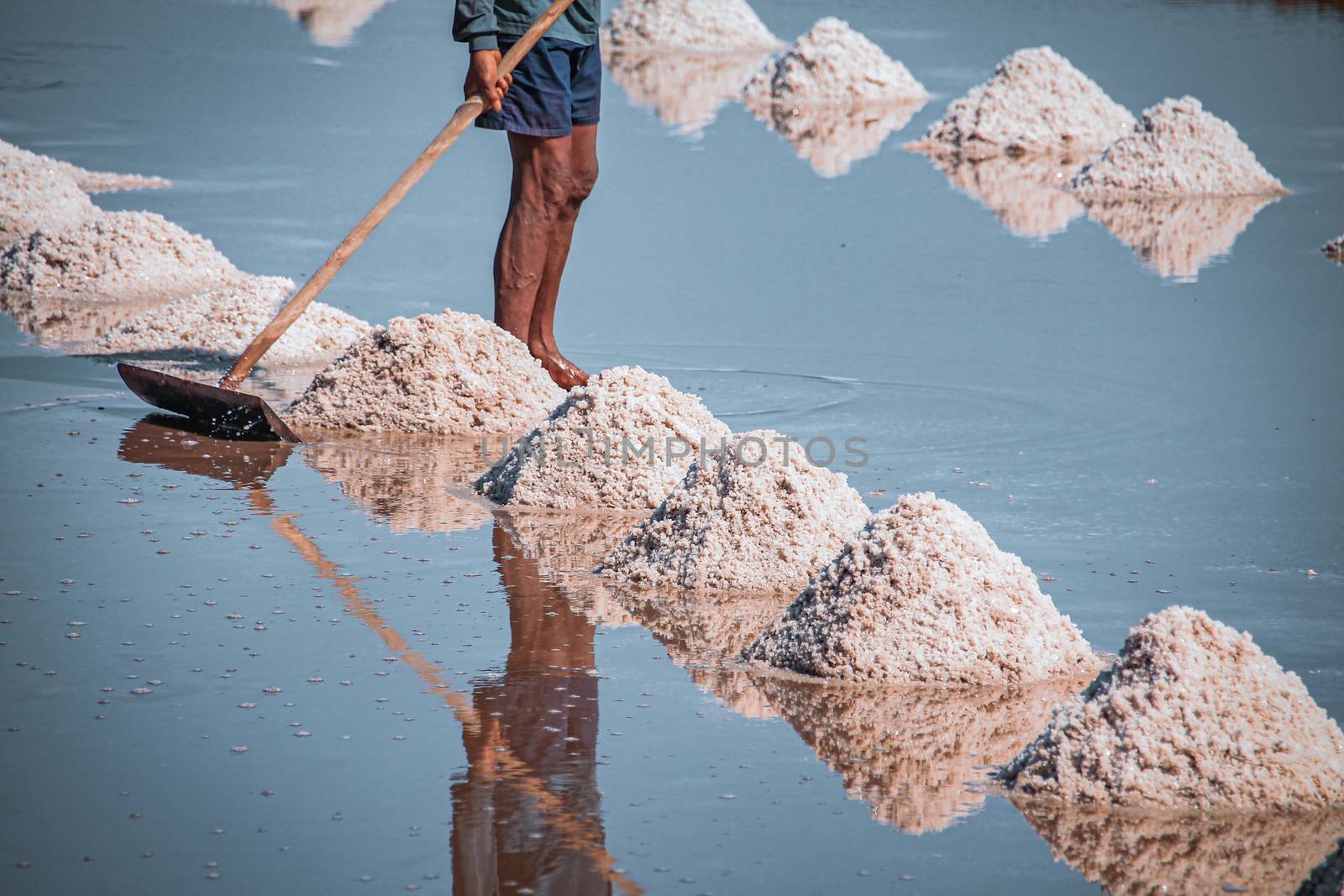Cinematic photo of traditional harvesting of salt in Kampot Province in Cambodia that shows the local culture, livelihood and real life of the Khmer people