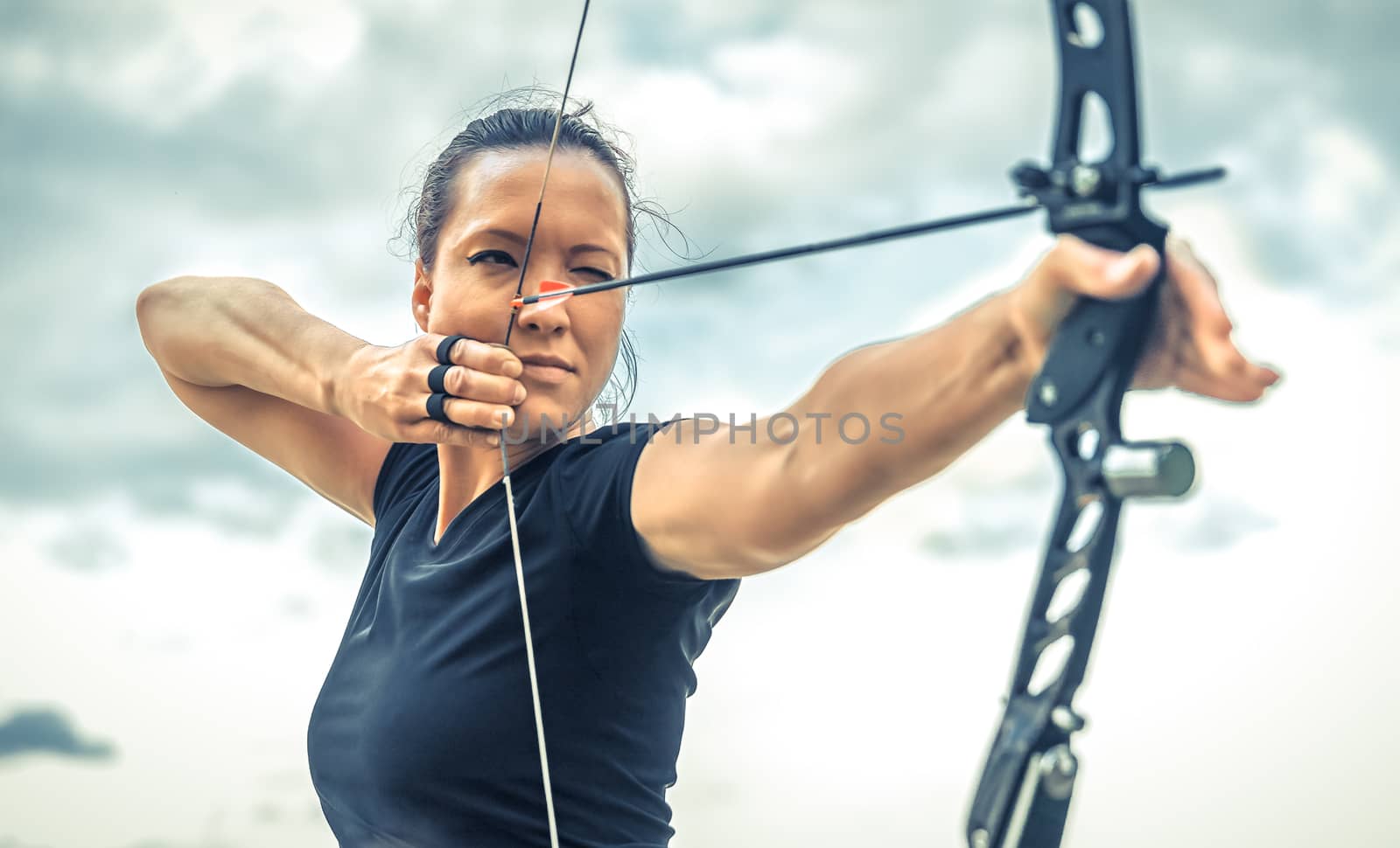attractive woman on archery, focuses eye target for arrow from bow