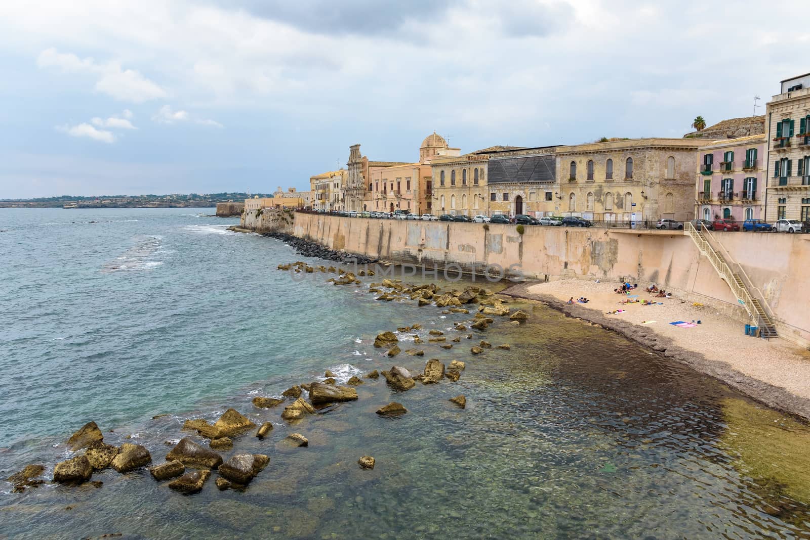 Waterfront with small pebble beach on Ortygia Island in Syracuse, Sicily, Italy