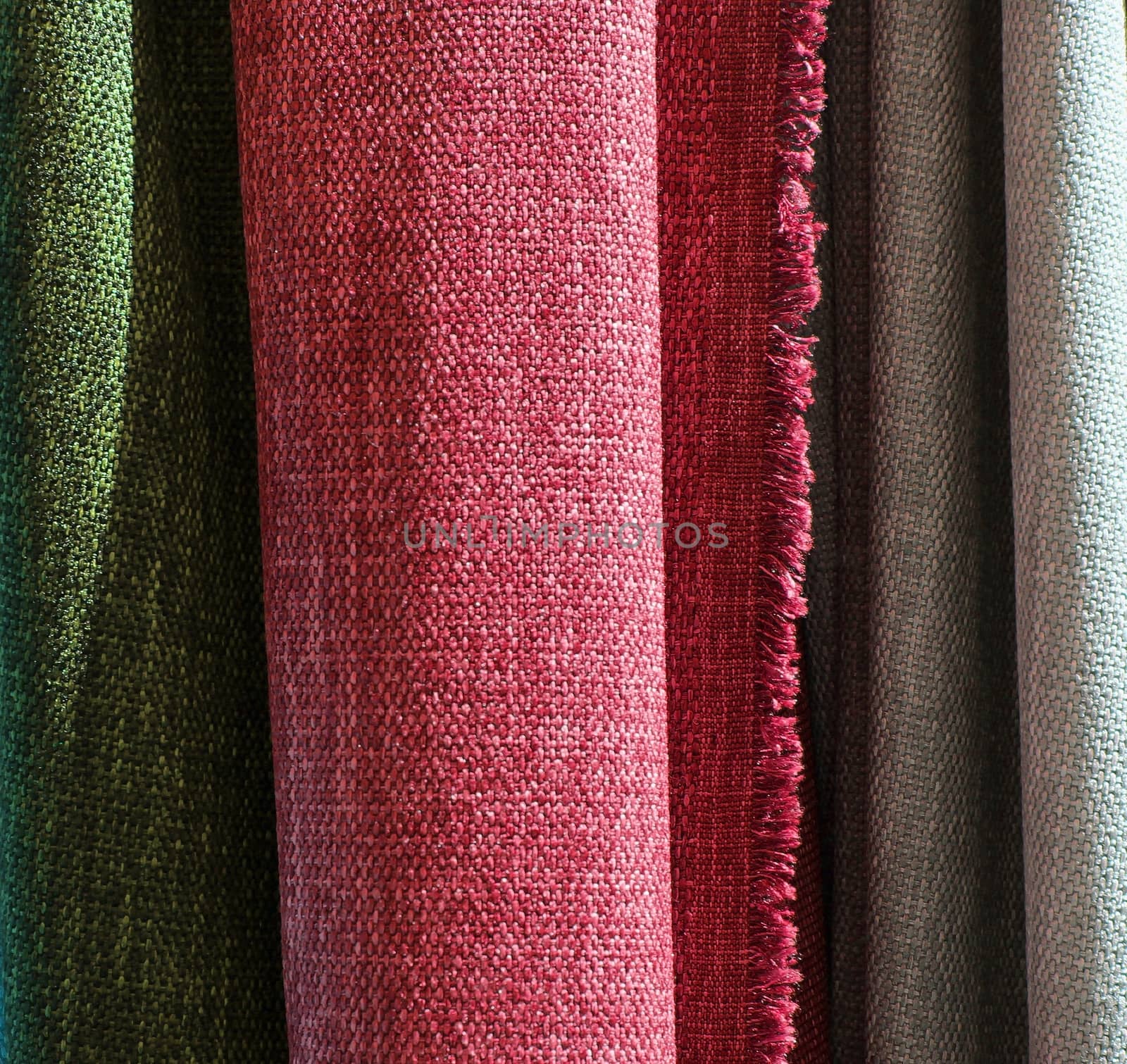 Detailed close up view on samples of cloth and fabrics in different colors found at a fabrics market.