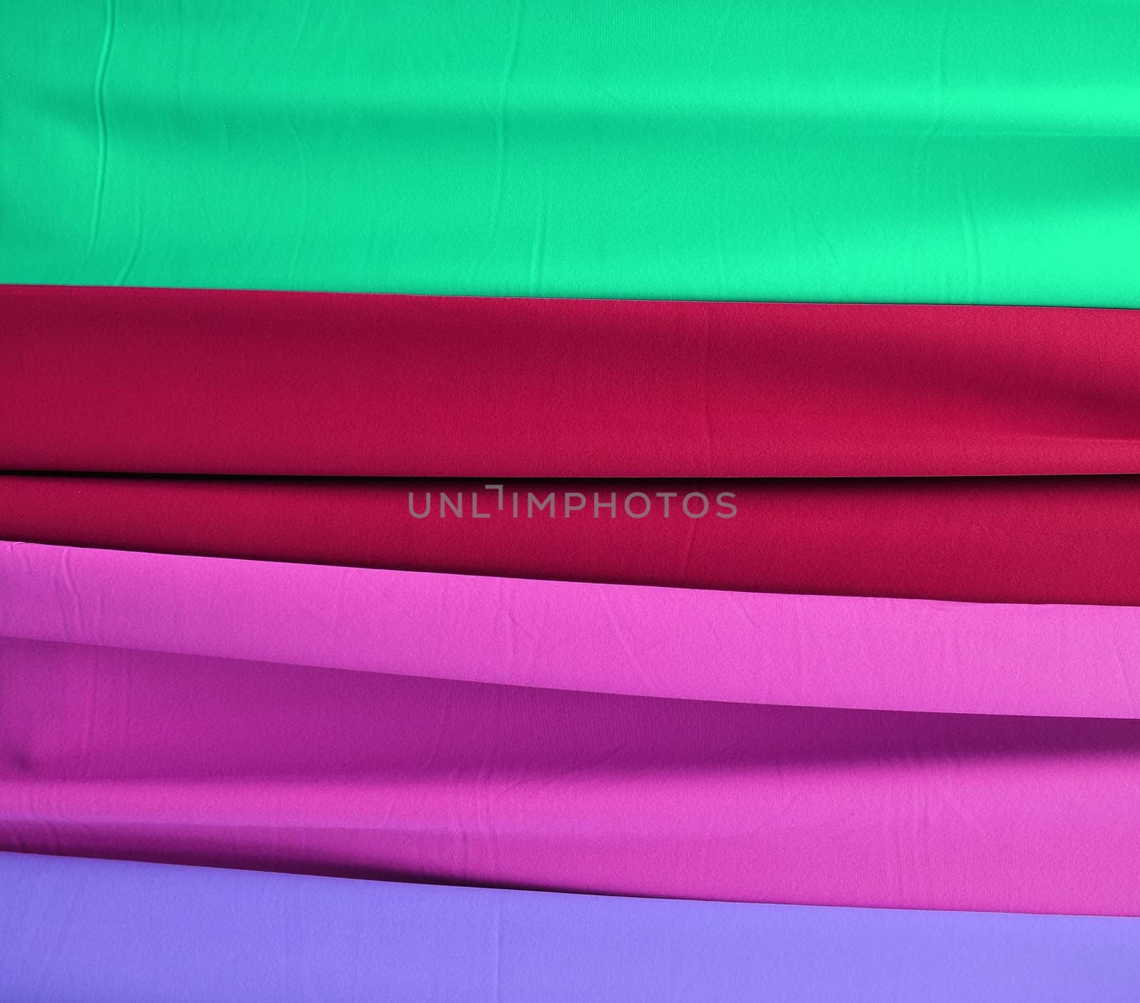 Detailed close up view on samples of cloth and fabrics in different colors found at a fabrics market.