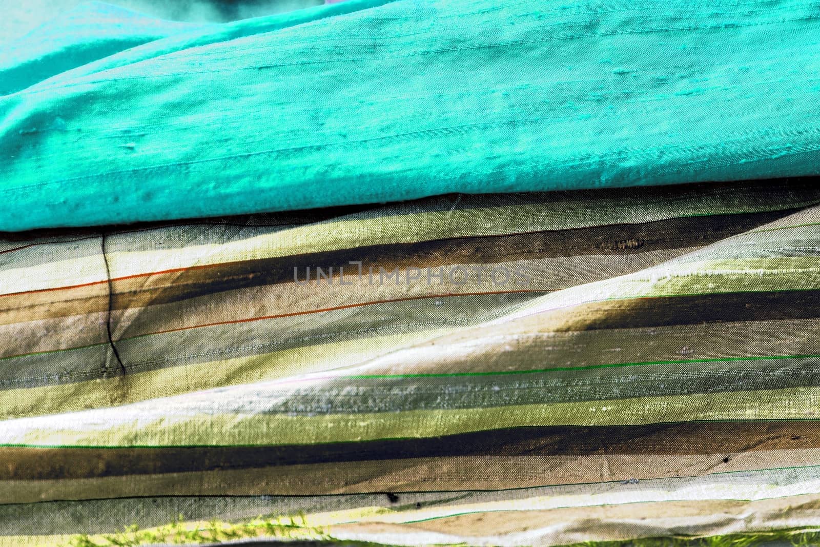 Detailed close up view on samples of cloth and fabrics in different colors found at a fabrics market.