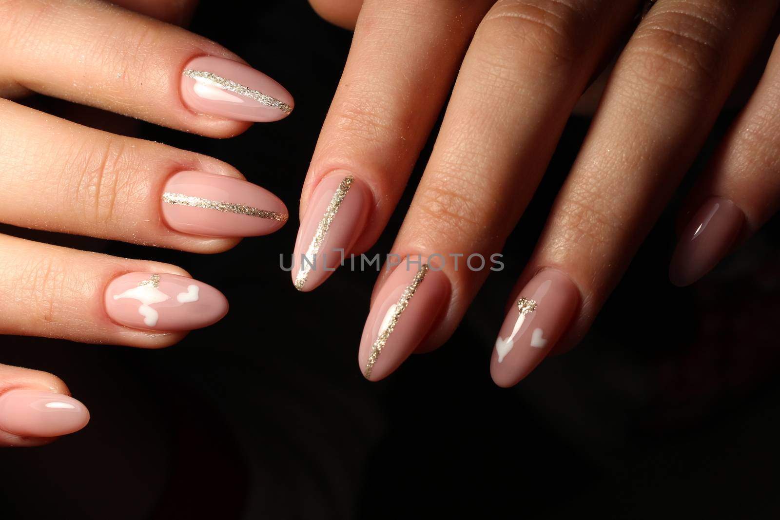Closeup of woman hands with nail design. Trendy crackle nail polish. Manicure and nail tattoo trend. Closeup of woman hands on black background. Fashion Stylish Fashion Colorful Nails.