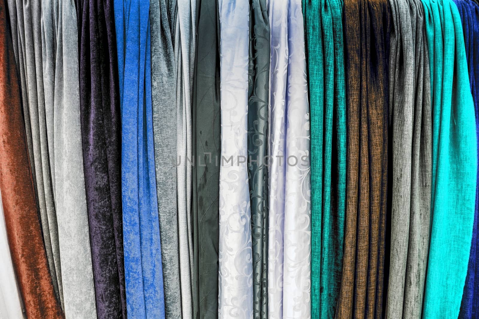 Detailed close up view on samples of cloth and fabrics in different colors found at a fabrics market.