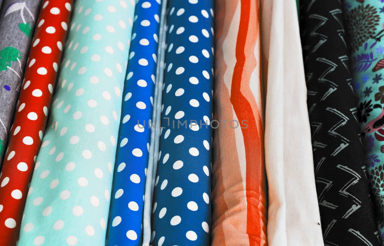 Detailed close up view on samples of cloth and fabrics in different colors found at a fabrics market.