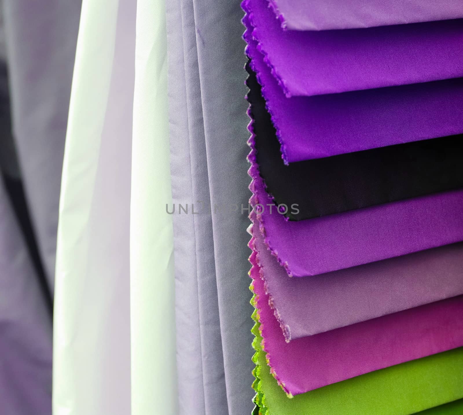 Detailed close up view on samples of cloth and fabrics in different colors found at a fabrics market.