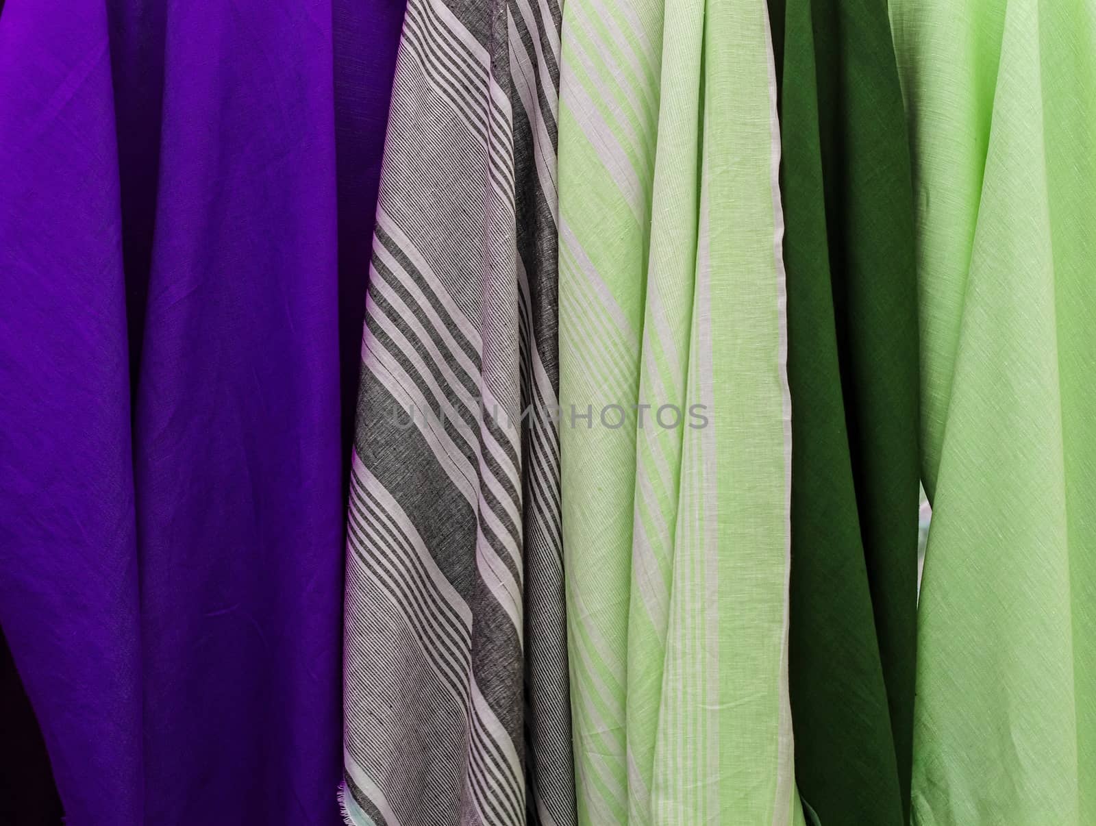 Detailed close up view on samples of cloth and fabrics in different colors found at a fabrics market.