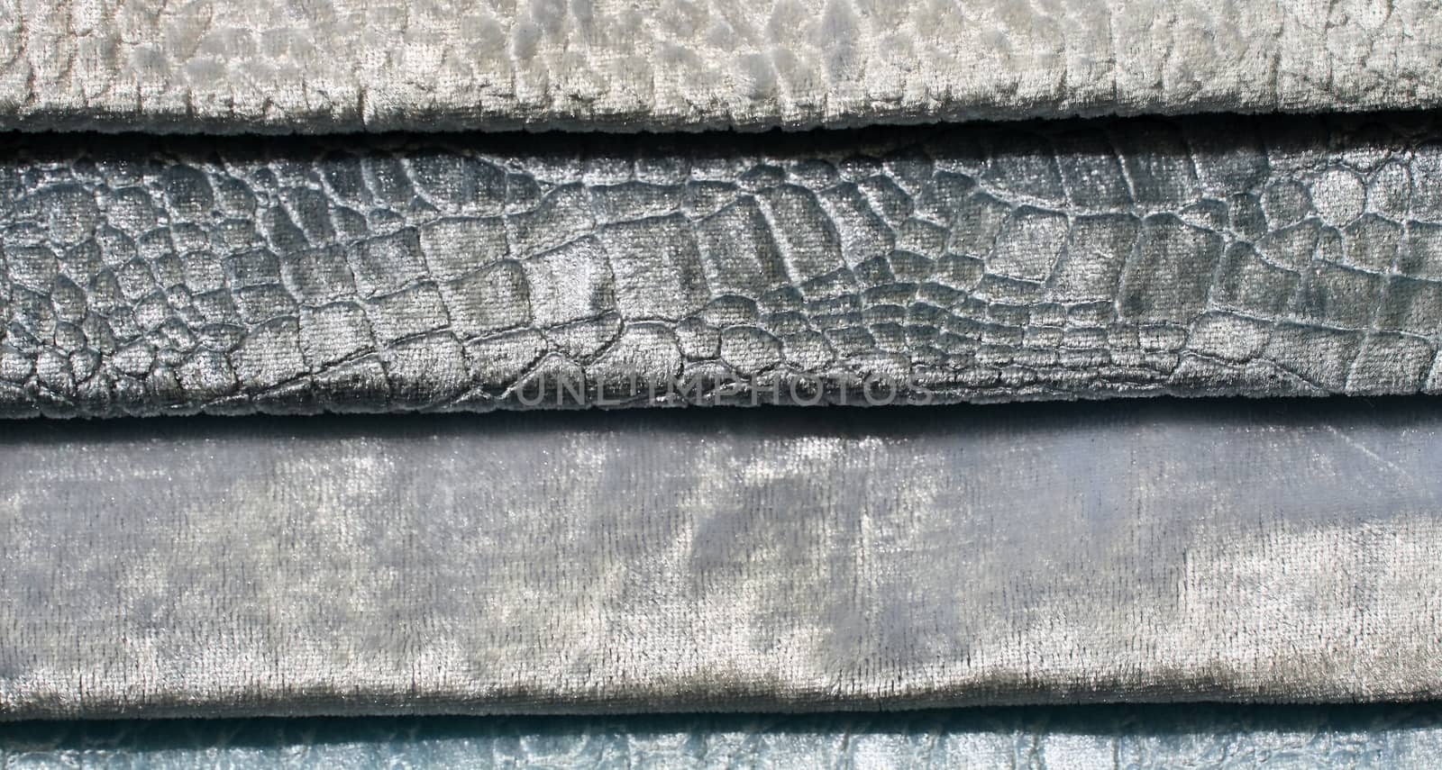 Detailed close up view on samples of cloth and fabrics in different colors found at a fabrics market.