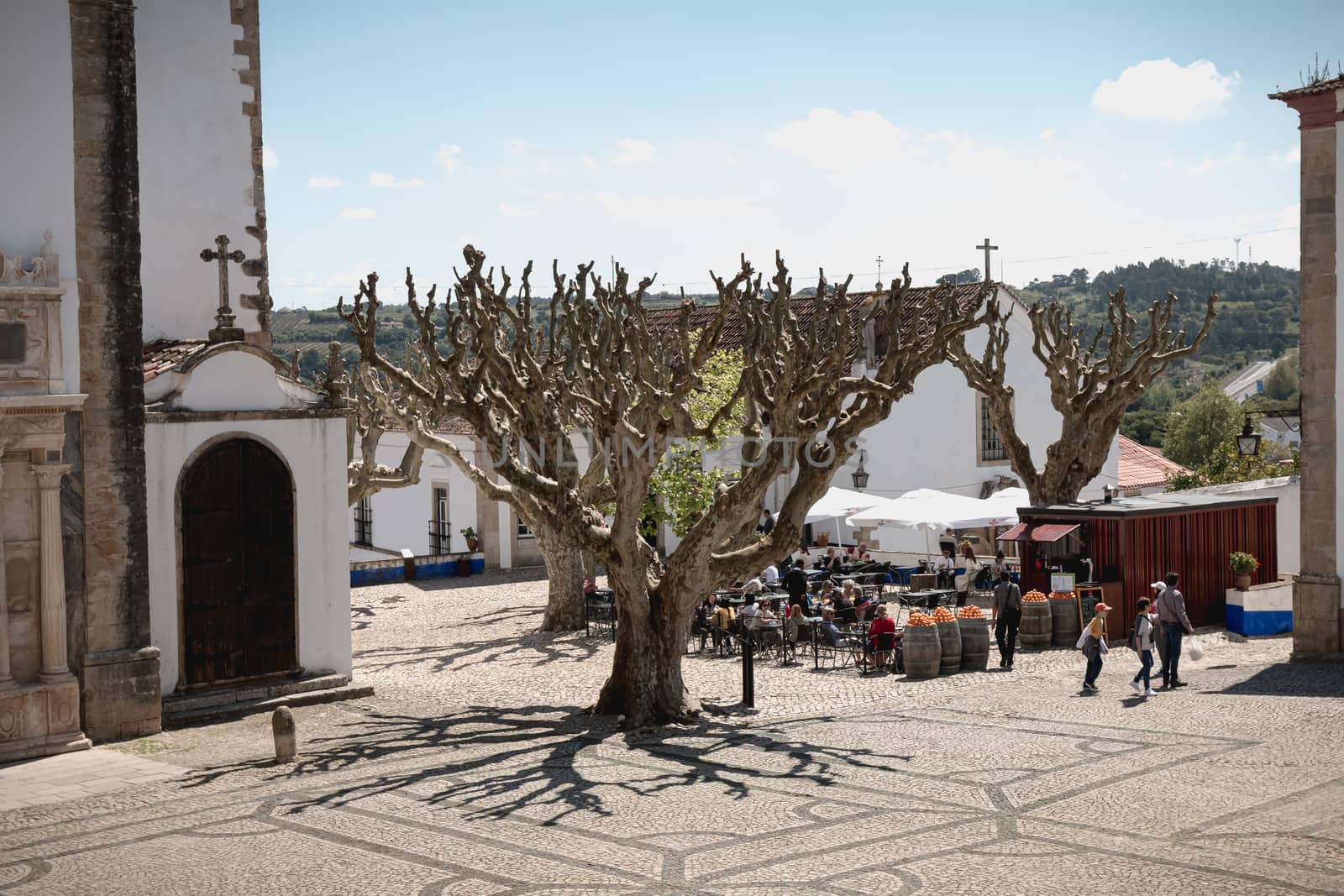 people walking around the Church of Saint Mary in obidos, Portug by AtlanticEUROSTOXX