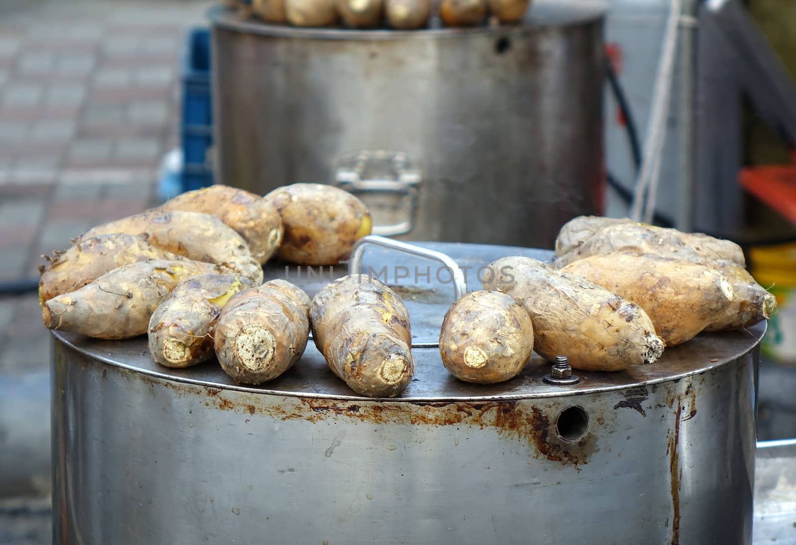 Baked sweet potatoes are kept warm on top of a steel oven
