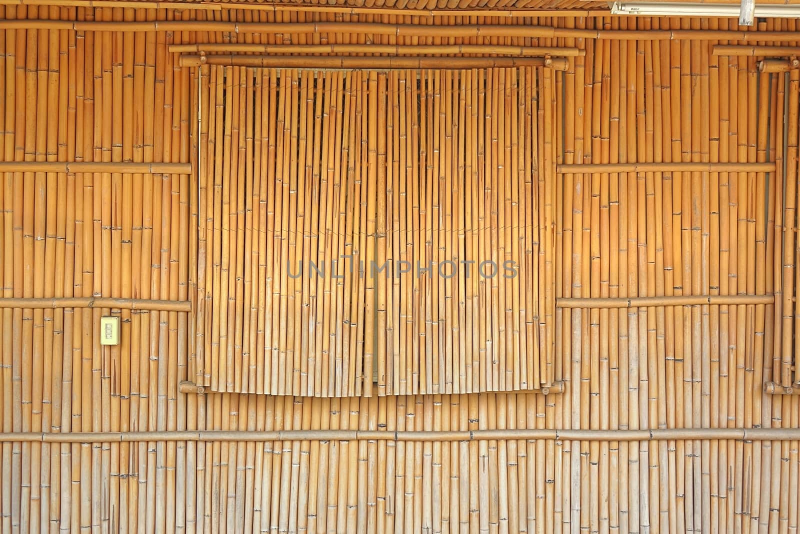 The wall and window shutters of a house are made from bamboo poles
