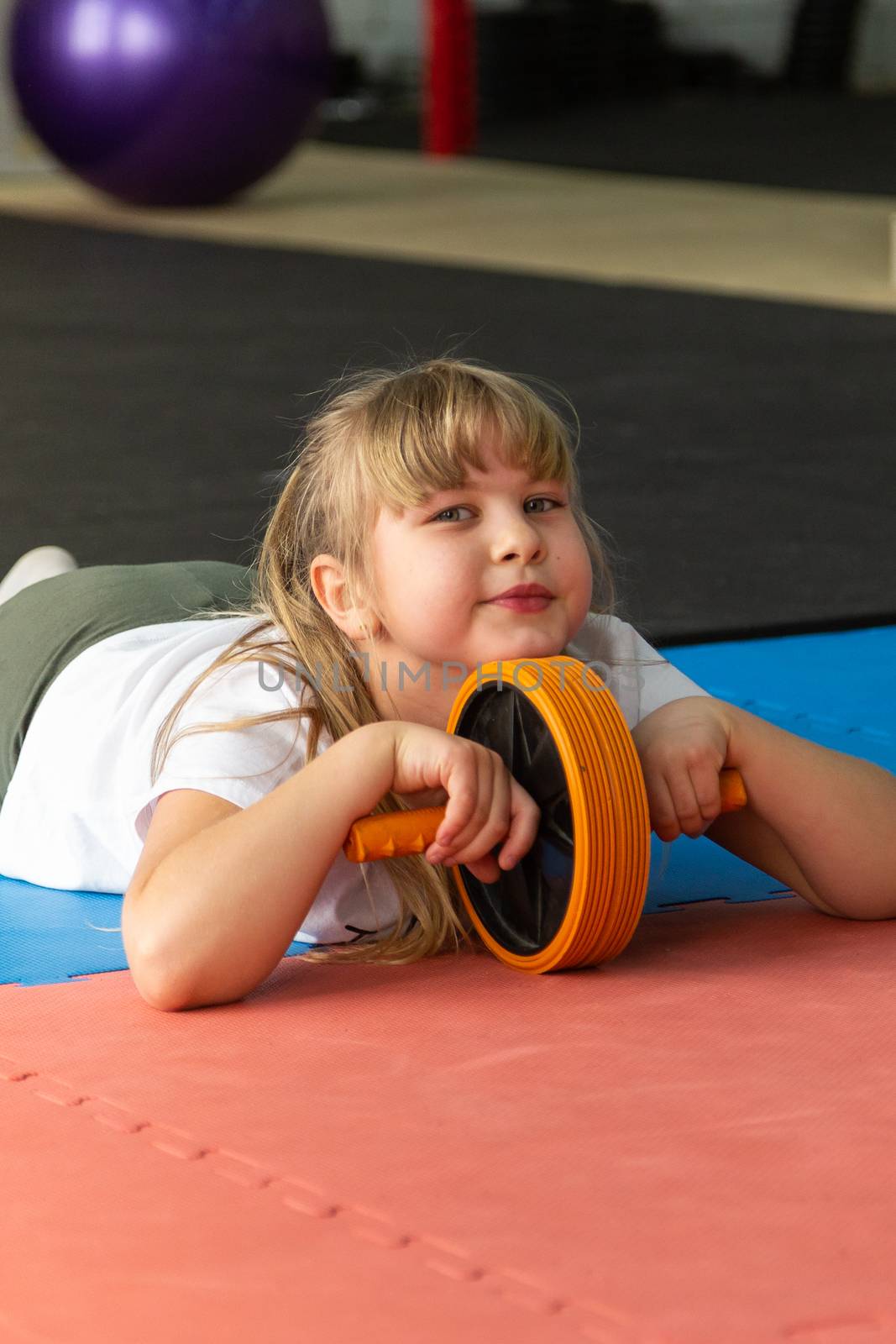 girl 8 years old with blond hair trains in the gym  by VADIM
