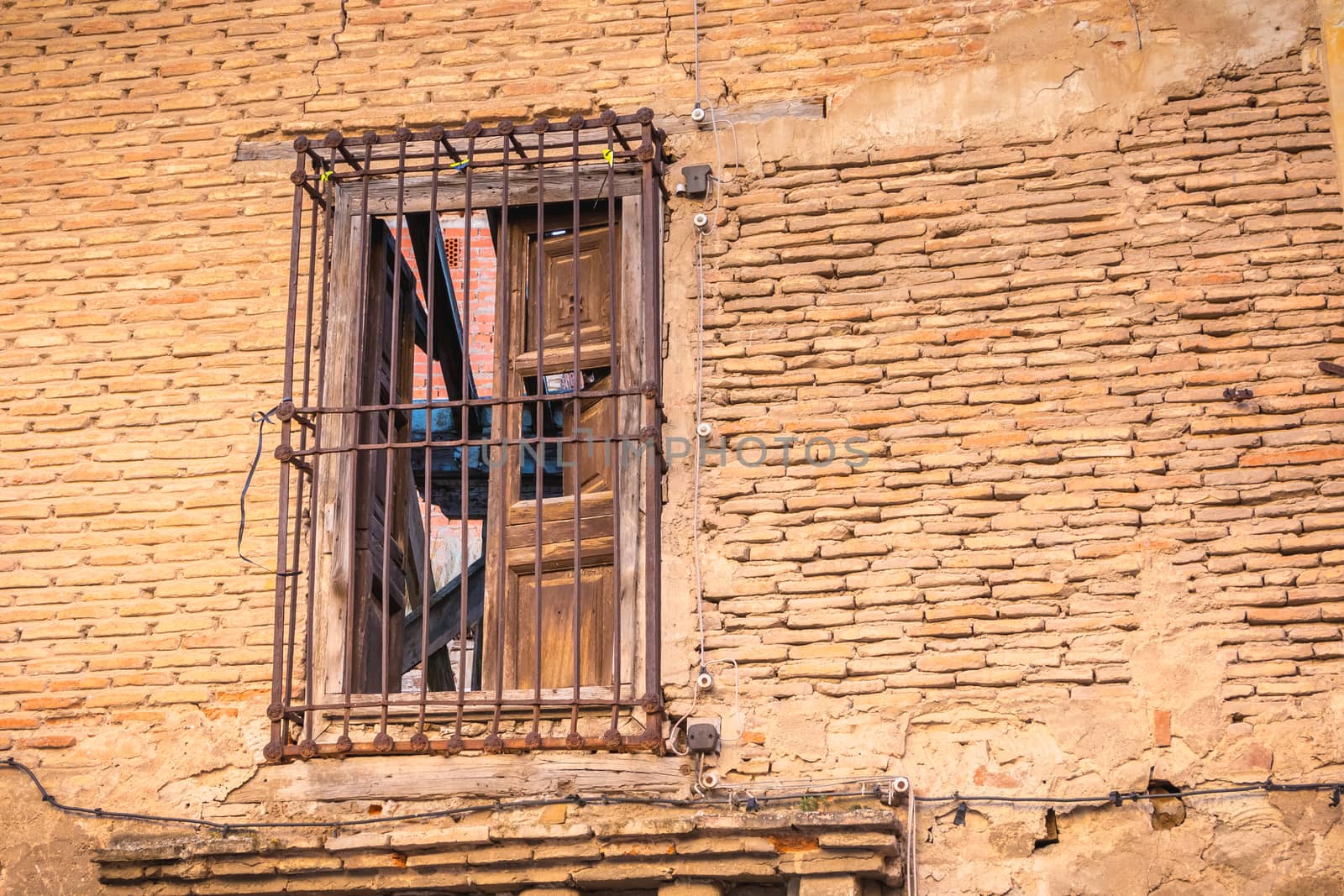 window protect from rusty metal bar on the brick wall of a ruined building