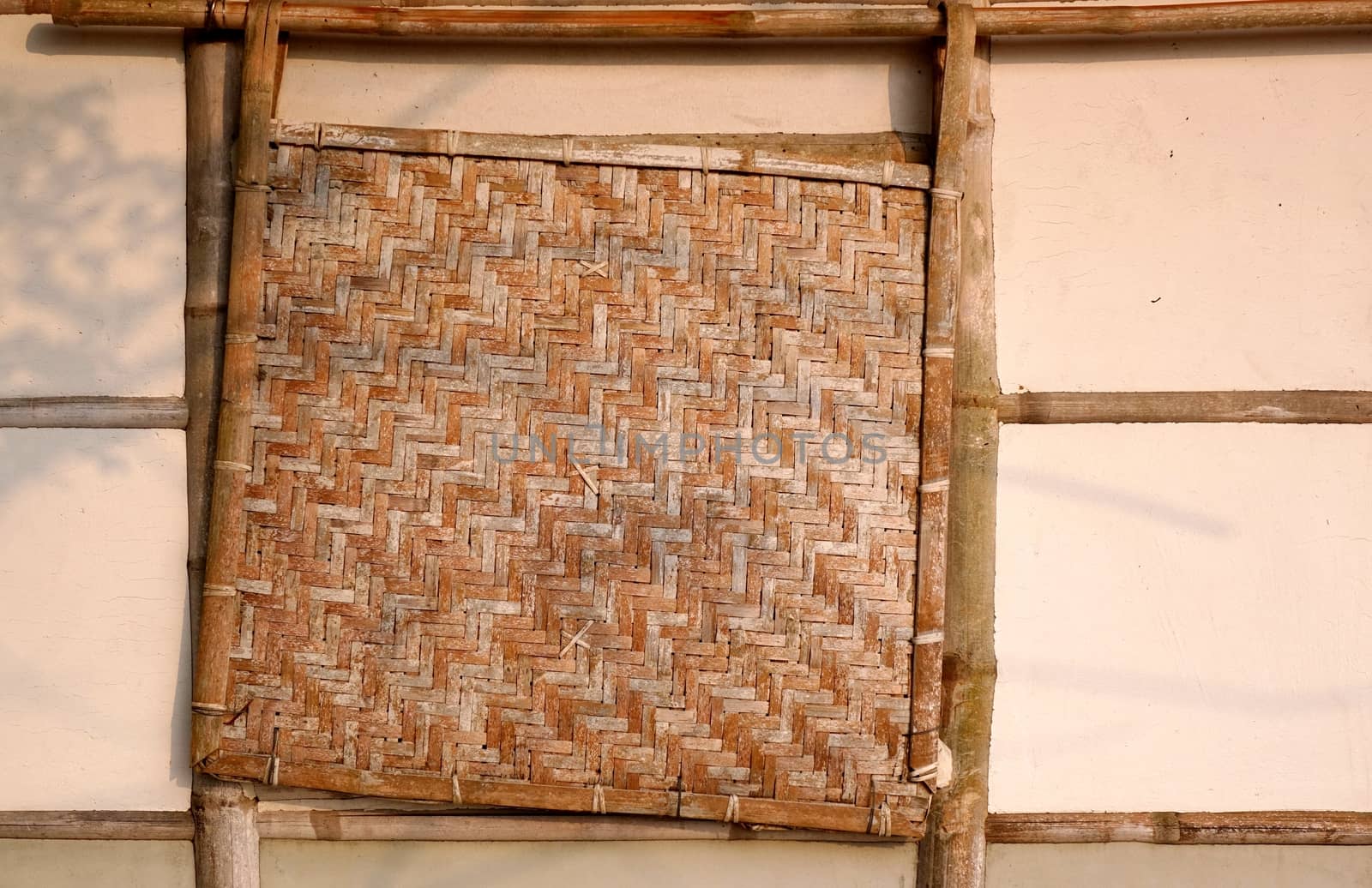 A traditional Chinese farmhouse made from bamboo with a bamboo window cover