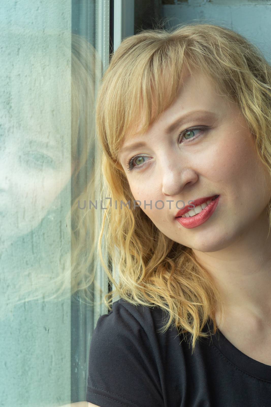 A woman of 30 years with blond hair near the window, you can see her reflection by VADIM