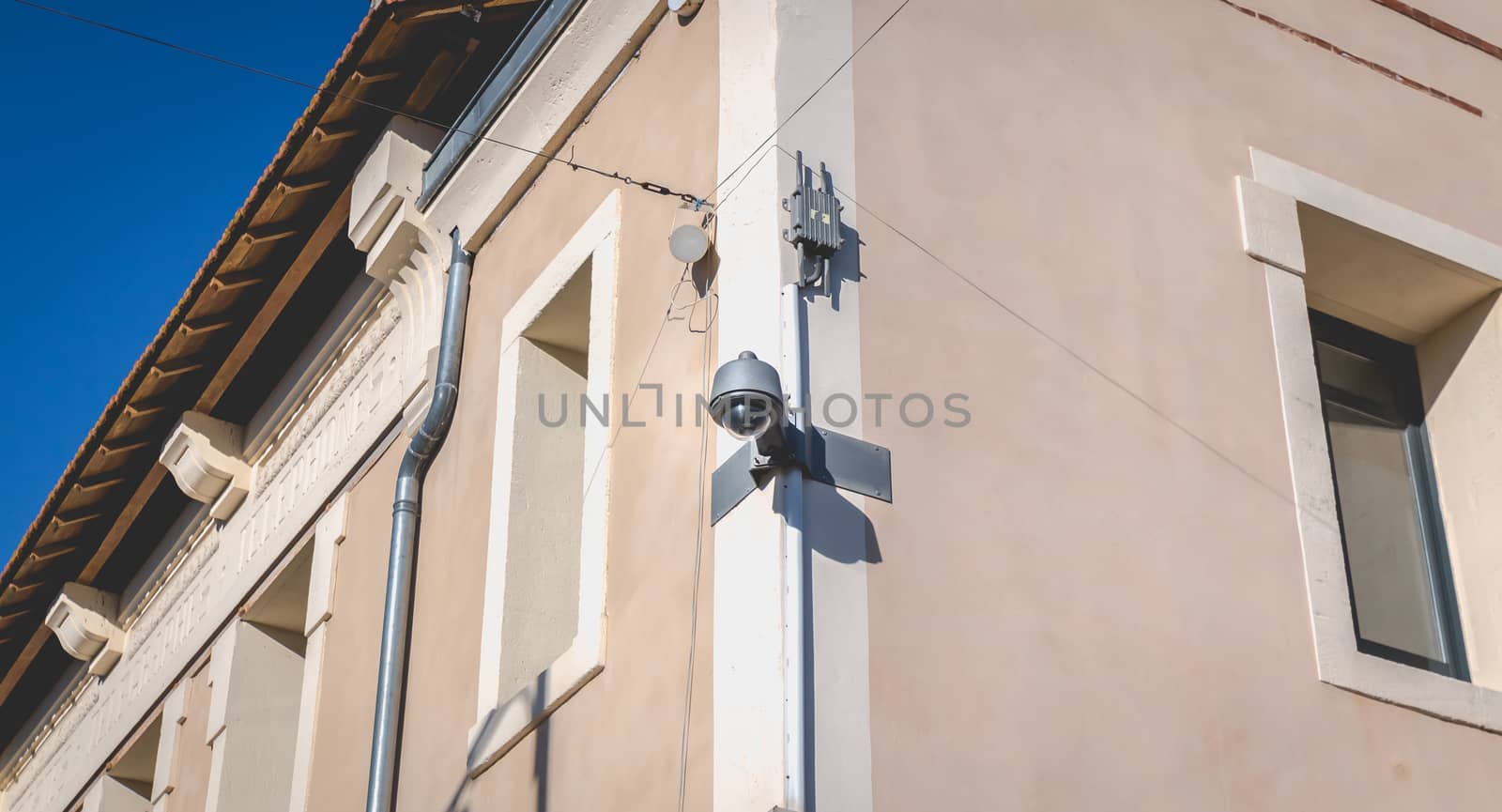 white CCTV surveillance camera on a stone wall