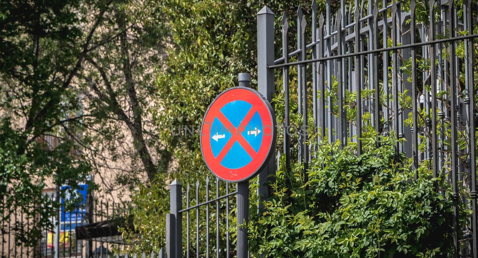 road sign no parking in front of a wrought iron gate by AtlanticEUROSTOXX
