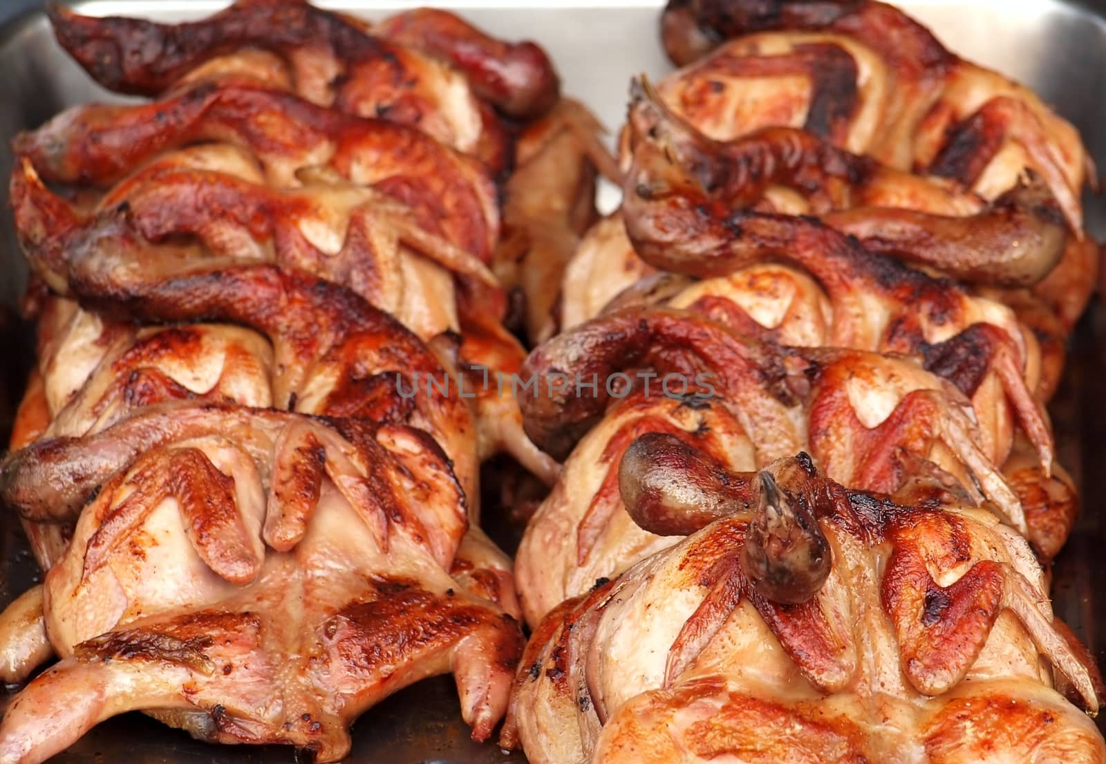 Grilled spring chickens for sale at an outdoor market