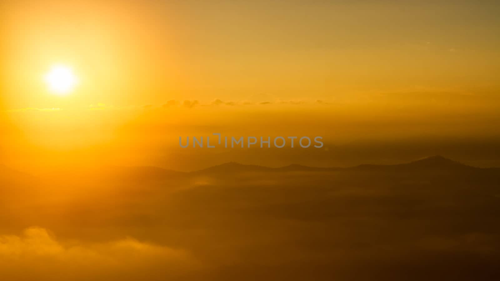 Scenic view of beautiful sunrise and mist over the mountains by ronnarong