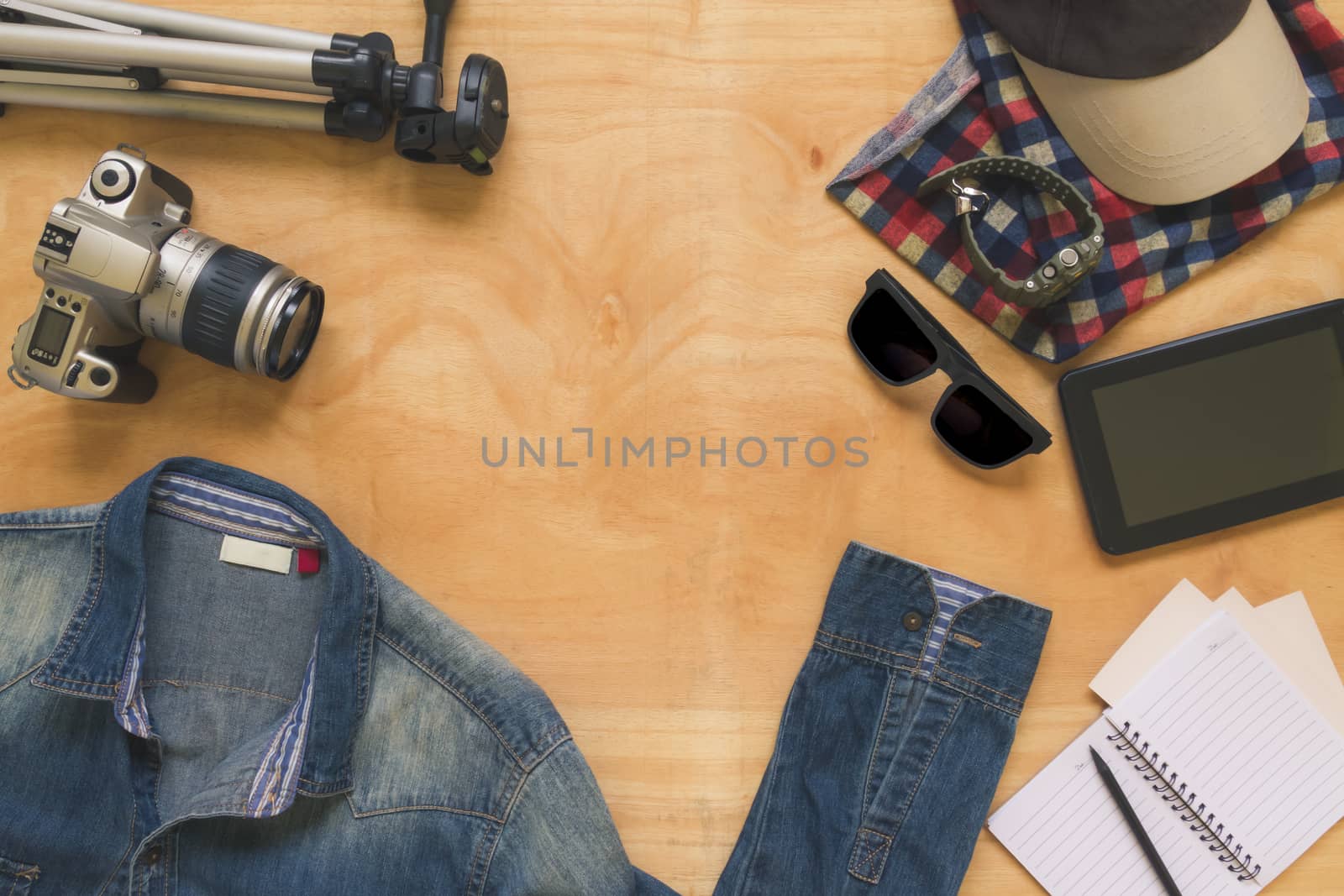 Top view of clothing and diverse personal accessory on the wooden table background.