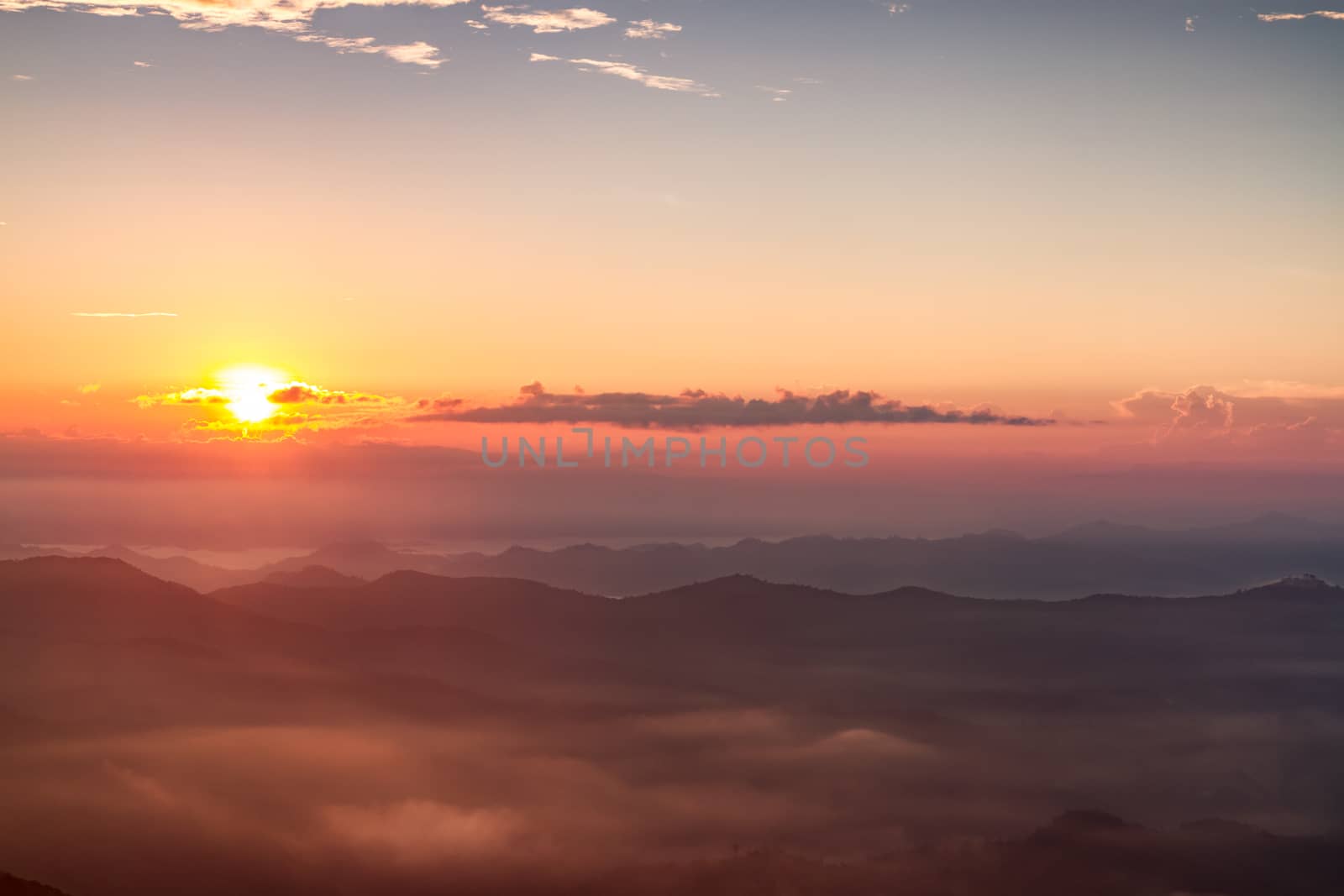 Scenic view of beautiful sunrise and mist over the mountains by ronnarong