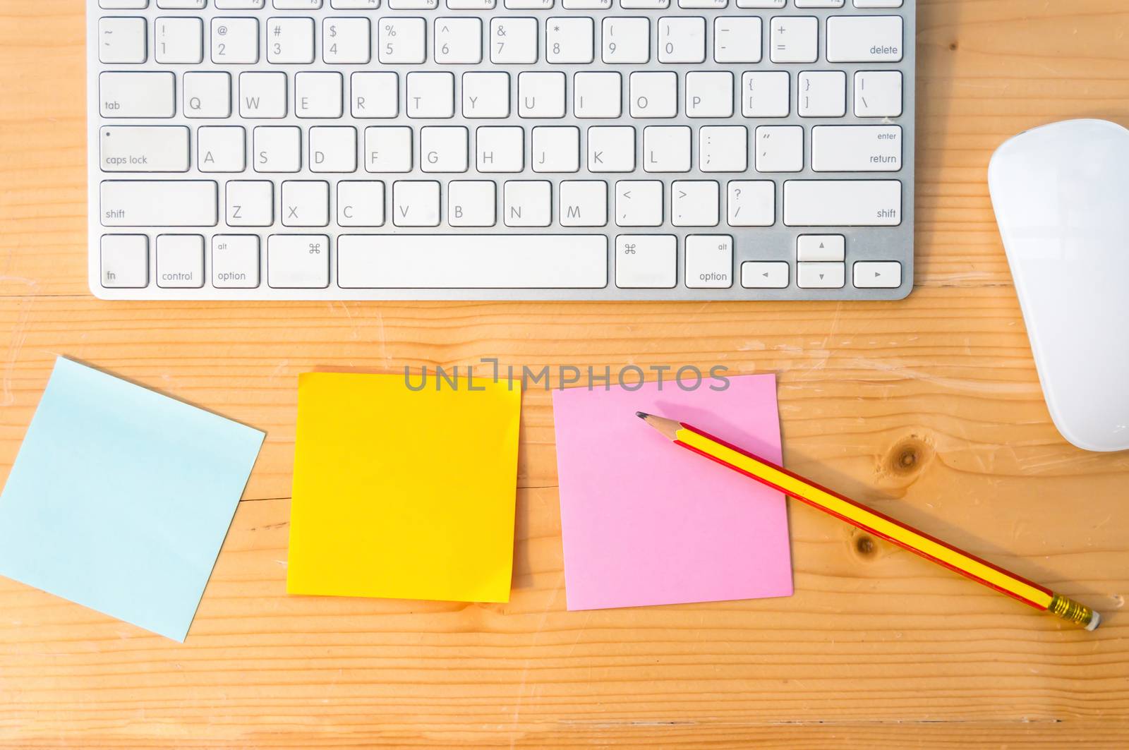Top view workspace with colorful sticky notes ,pencil, keyboard and mouse on wooden table background.