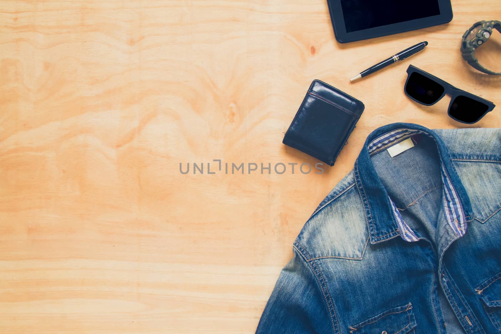 Top view of clothing and diverse personal accessory on the wooden table background.