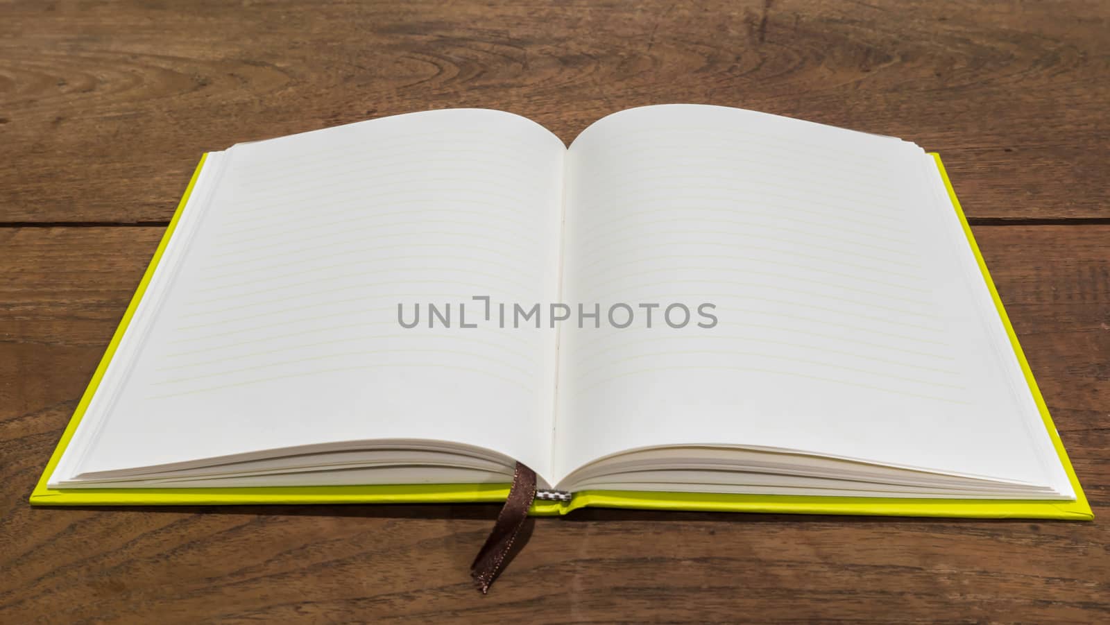 Blank notebook  on wooden table. by ronnarong